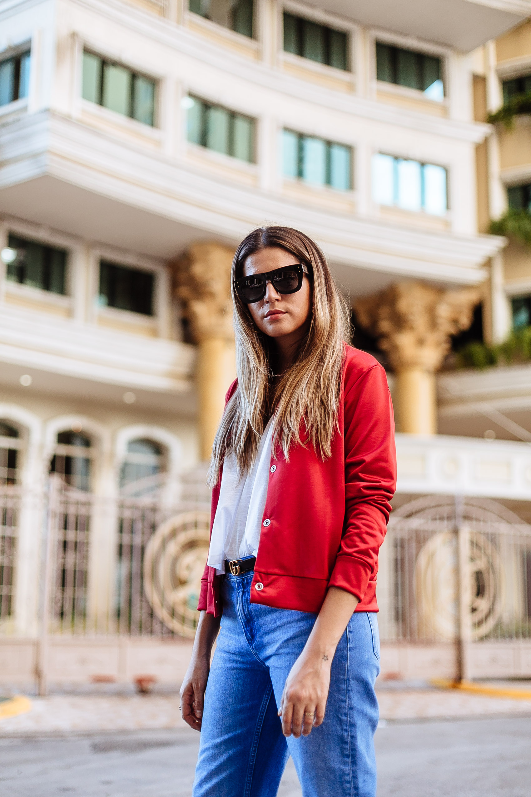 Blogger Maristella Gonzalez wearing a red satin jacket, white tank top, jeans and Gucci belt