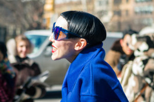 Michelle Harper wearing blue sunglasses and coat at NYFW