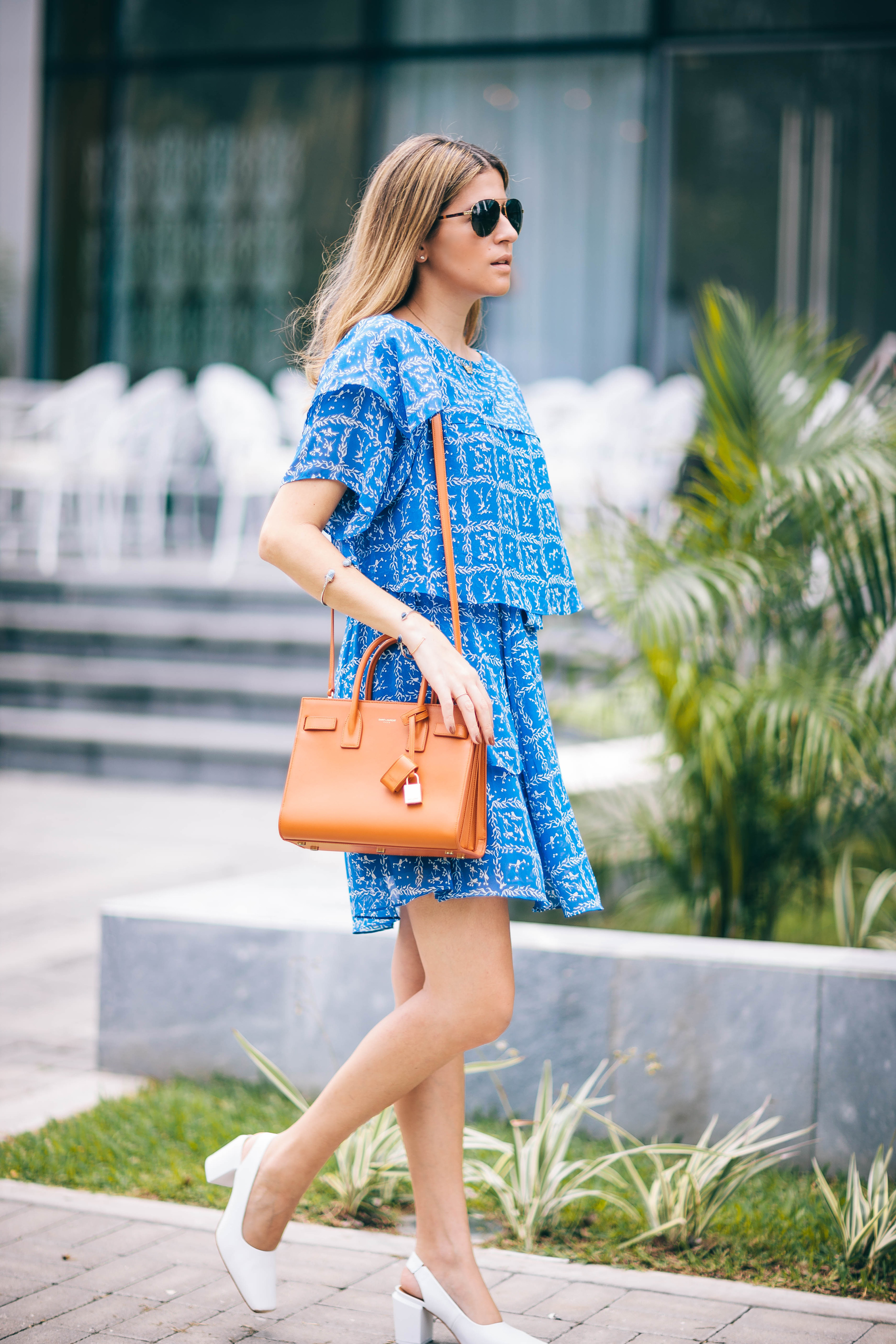 Blogger Maristella wears a feminine dress with a structured shoulder bag