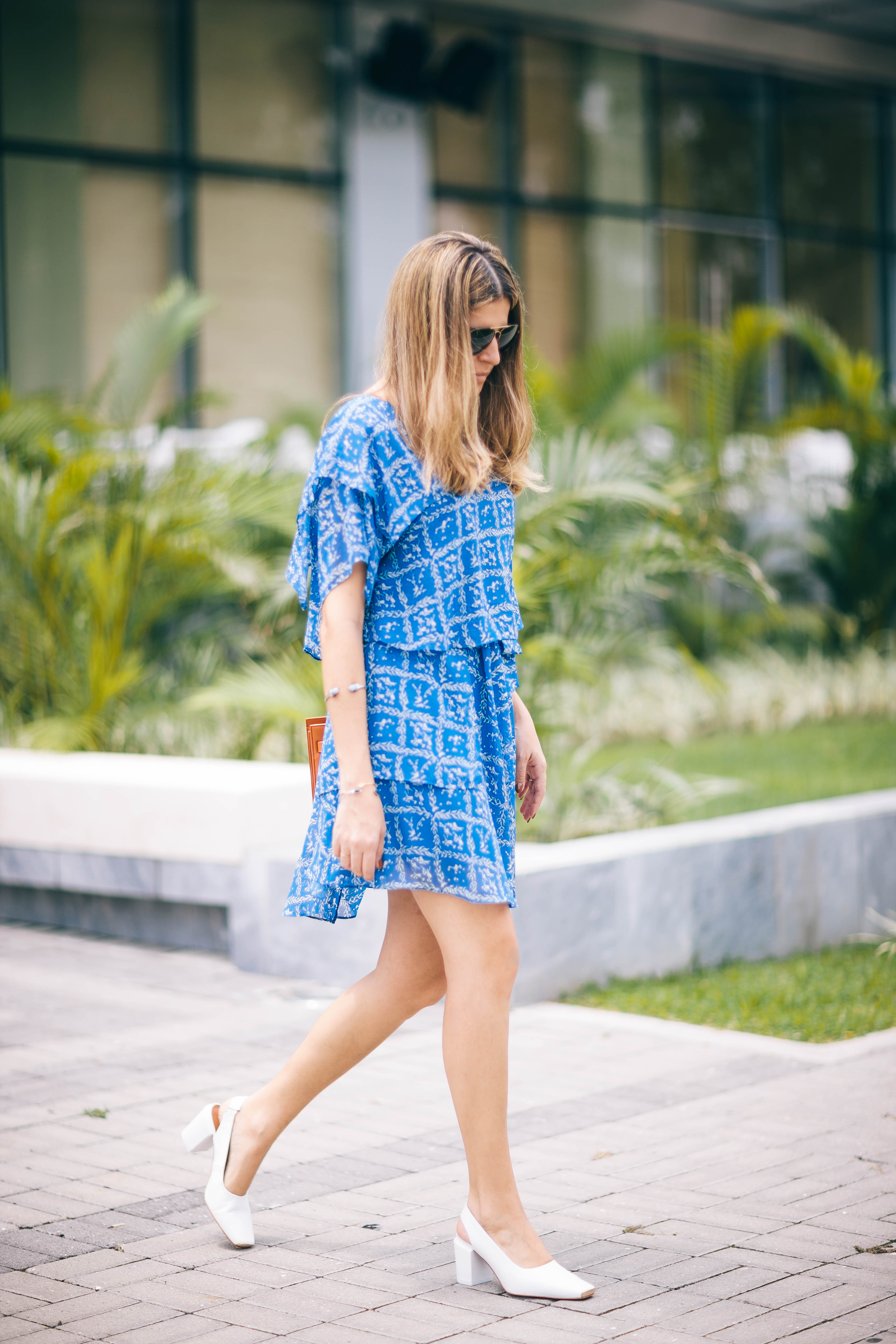 Style blogger Maristella in a ruffled chiffon dress and white square toe heels
