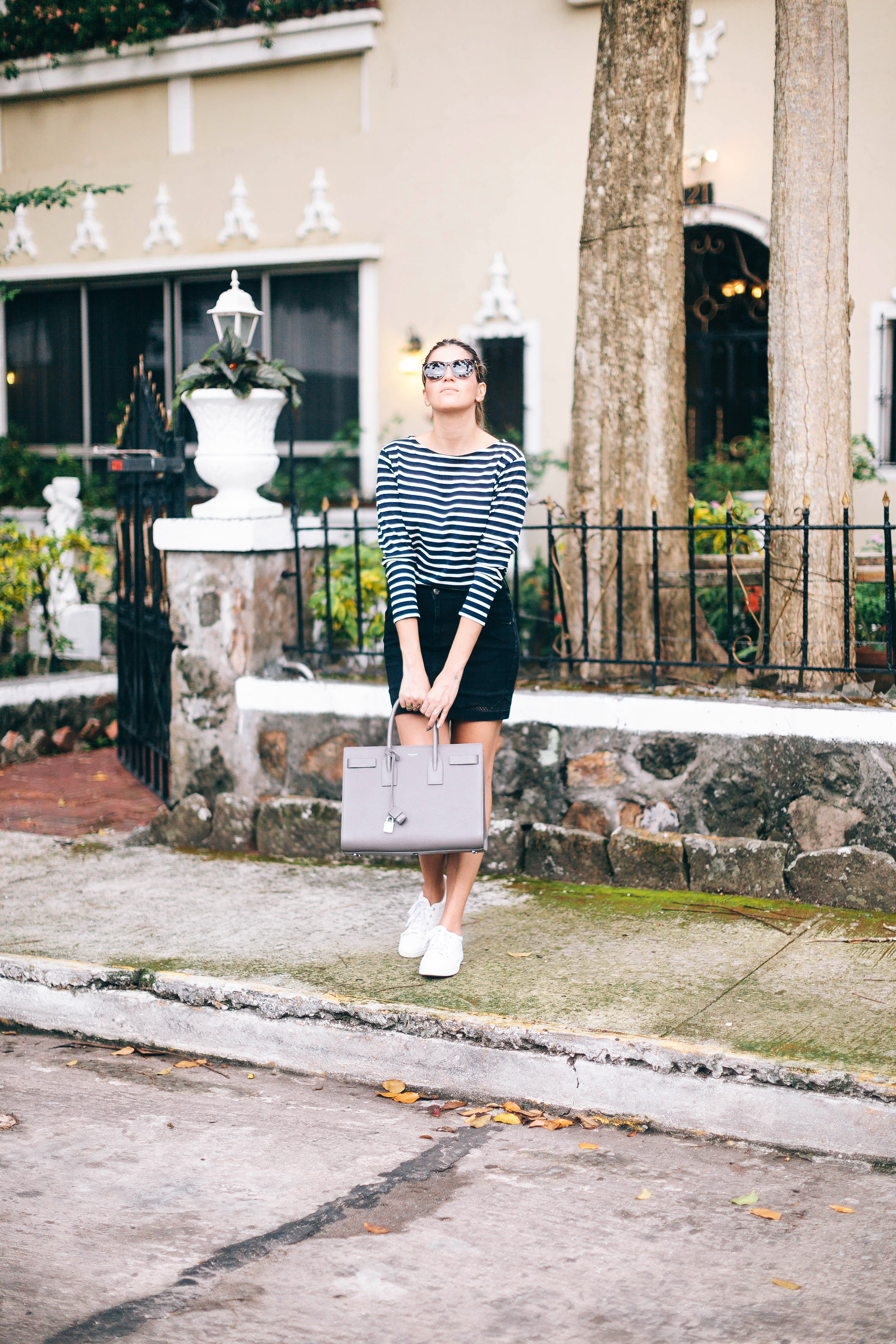 Casual, comfortable basics outfit with striped t-shirt, black skirt, white sneakers, gray bag and tortoise sunglasses
