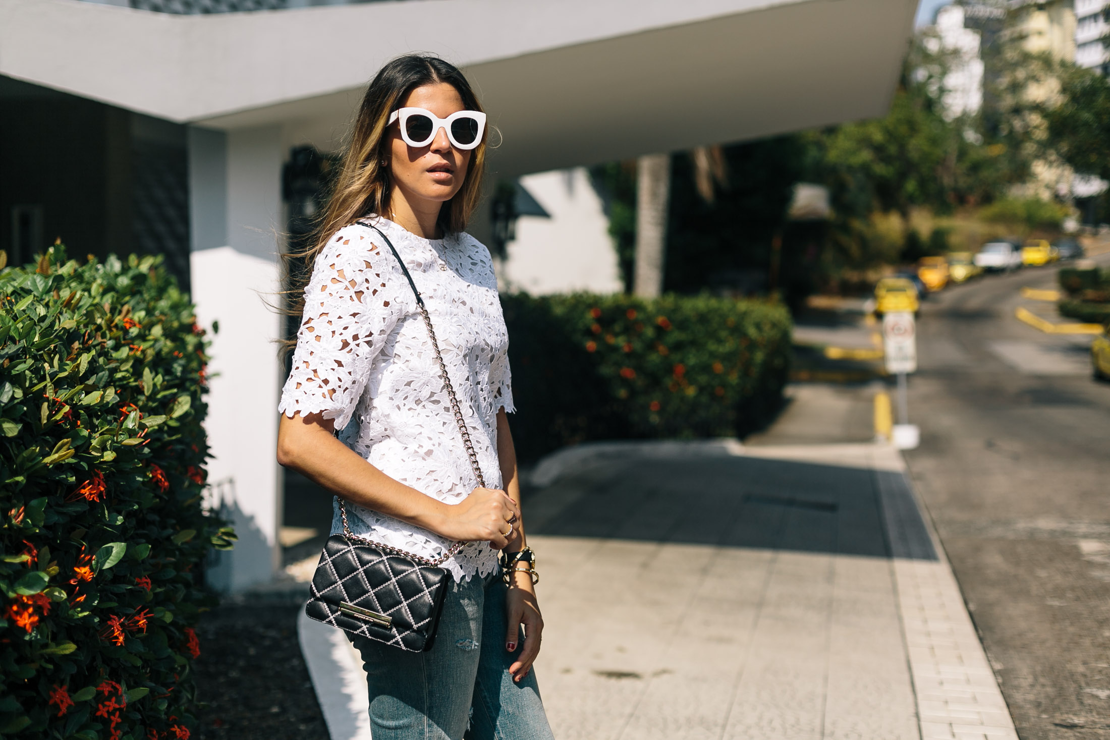 Casual everyday outfit idea with a fresh white lace top, jeans and small crossbody bag