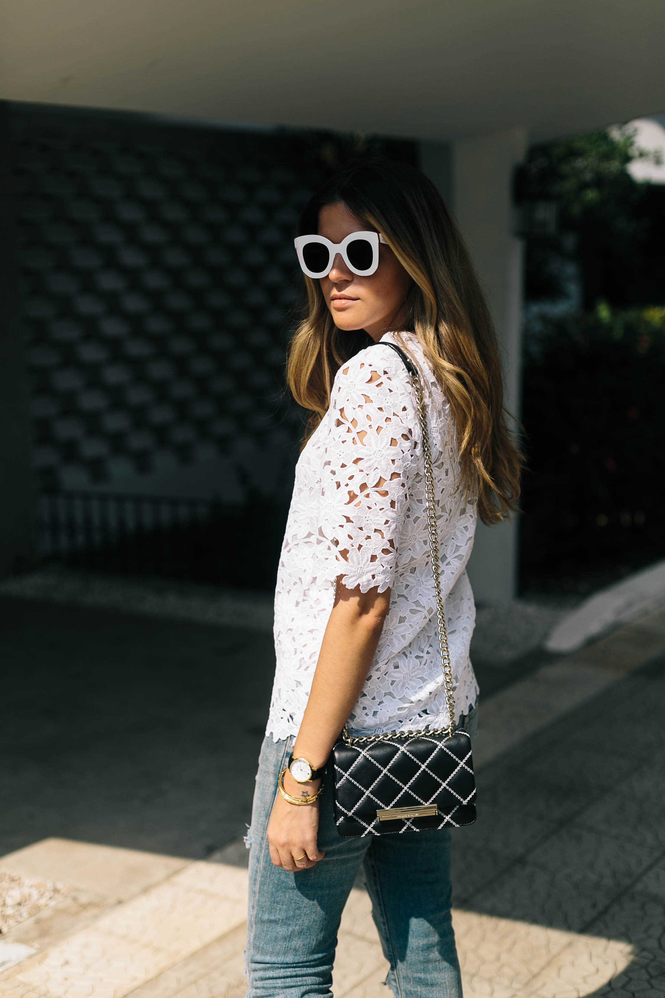 Panama blogger Maristella wears white oversize Céline sunglasses, white lace top and bag from Kate Spade, jeans from Saint Laurent