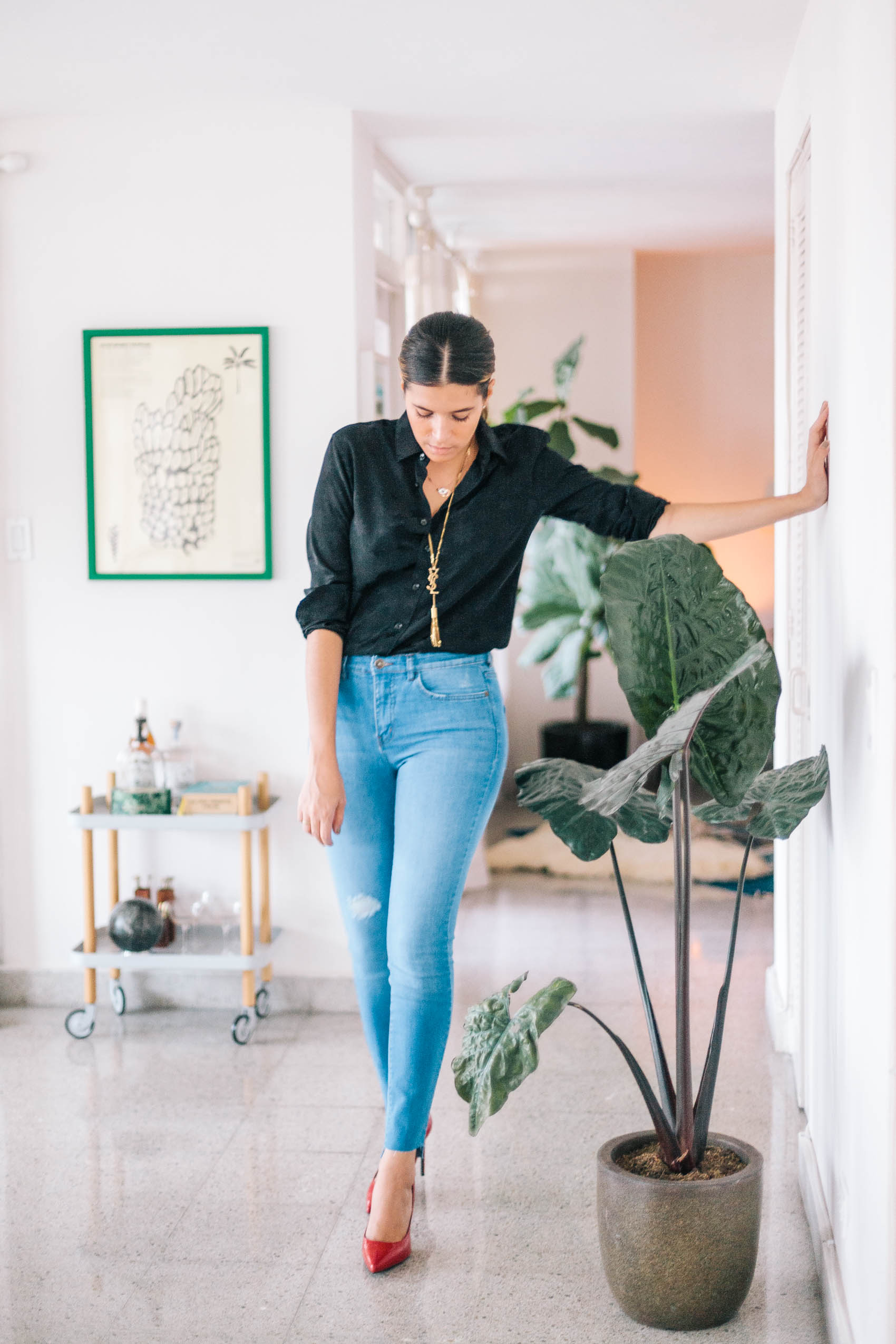 Blogger Maristella from Panama wears a YSL black silk star jacquard button down blouse, high waisted light blue wash skinny jeans with distressed detail and DIY cut ankle hems, Saint Laurent Paris patent leather pumps in red