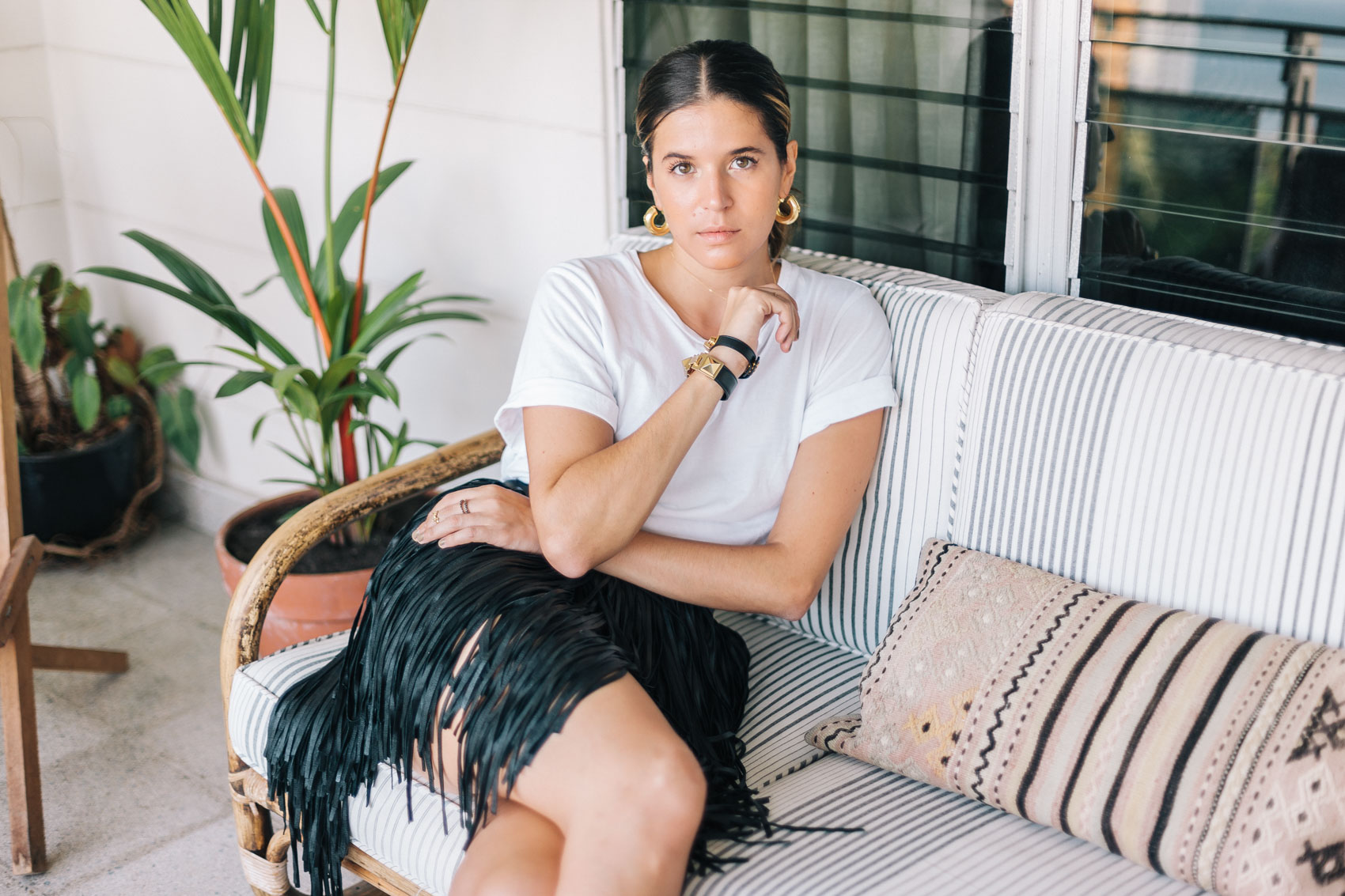 Black and white outfit idea by Maristella Gonzalez, featuring a fringe leather mini skirt and bracelets from Saint Laurent, basic white t-shirt from Cheap Monday