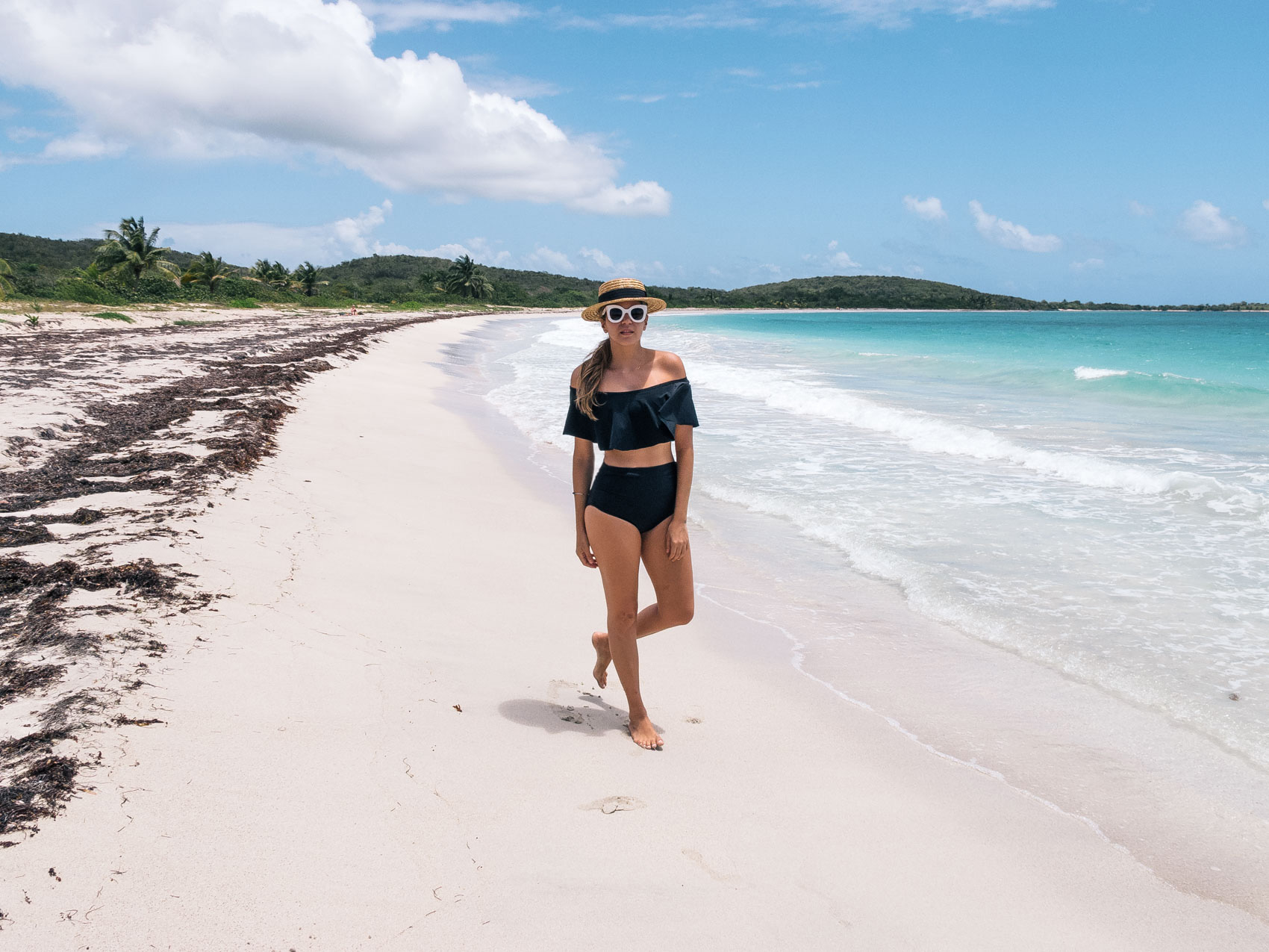Pristine beaches in Vieques Puerto Rico, Maristella wears a straw boater hat from Zara, off the shoulder black bikini with high waisted bottoms