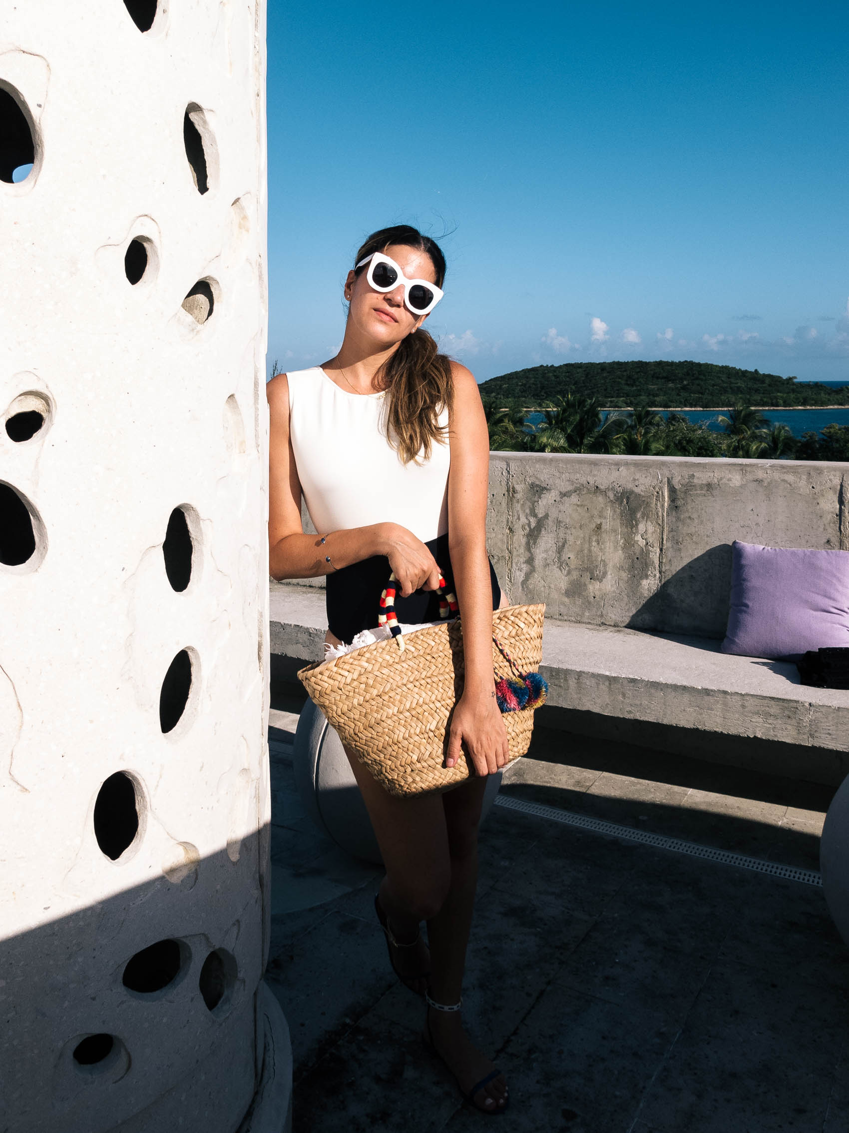 Maristella wearing Celine sunglasses, Lenny Niemeyer one piece bathing suit and a straw tote bag with poms at El Blok hotel in Vieques Island Puerto Rico