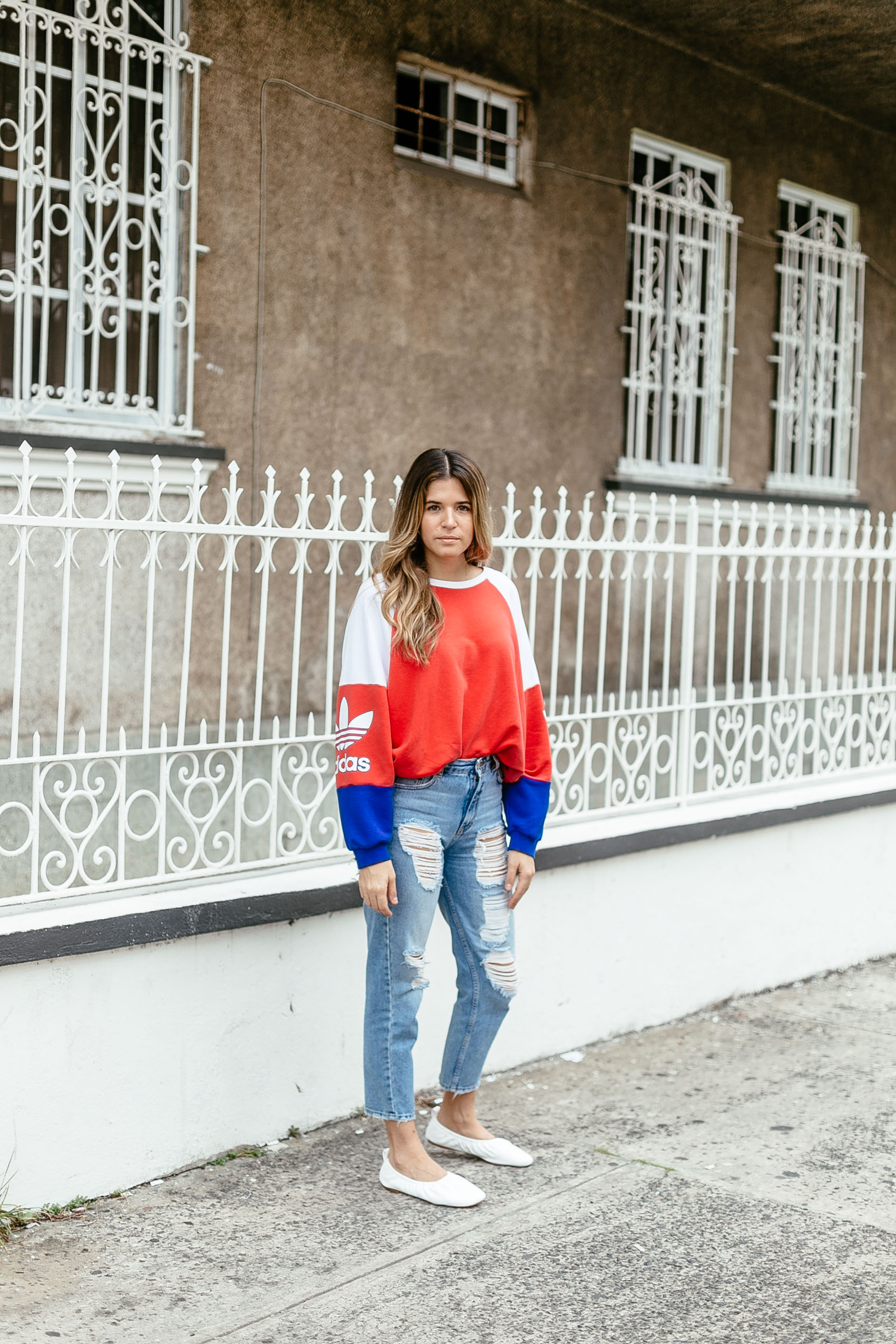 Maristella wearing an adidas jumper with distressed mom jeans and Céline flats