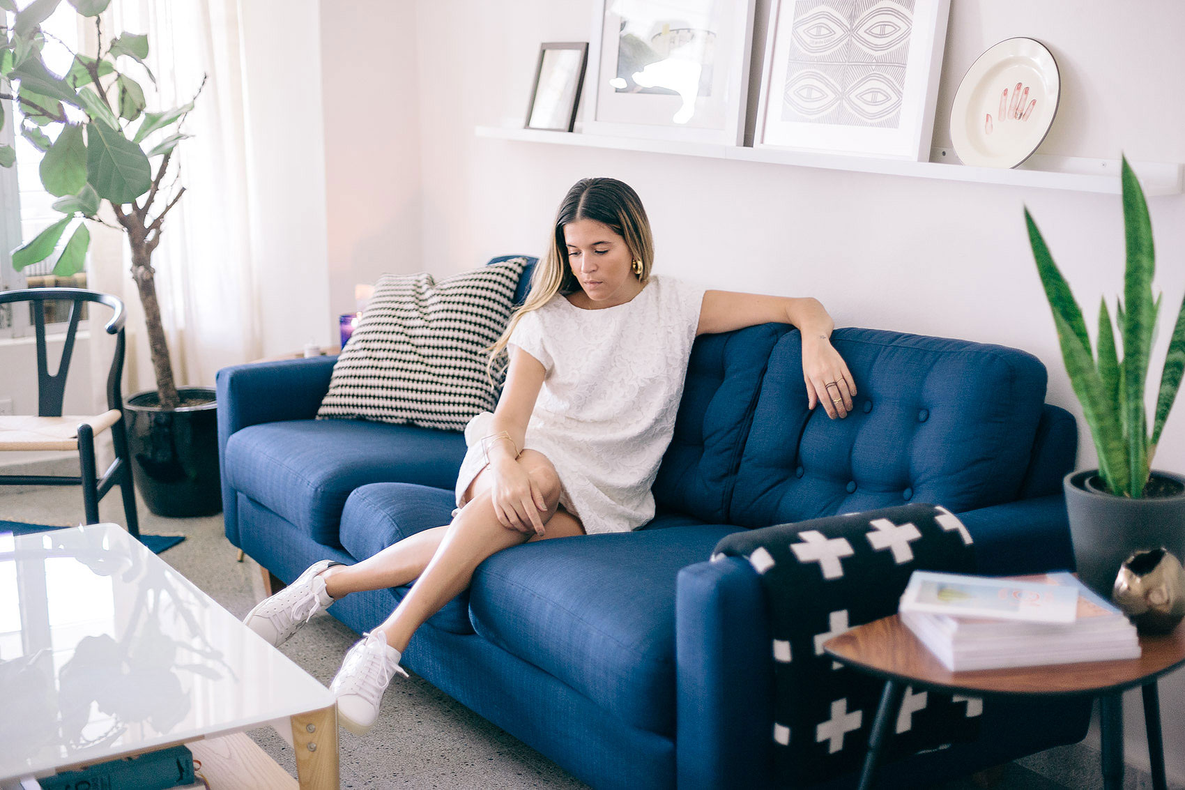 Blogger Maristella in her living room decorated with a blue sofa and Scandinavian accents