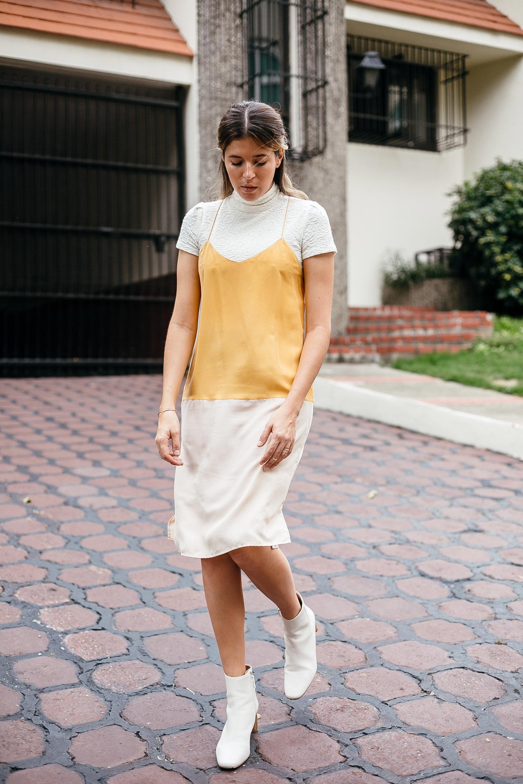 Blogger Maristella wearing a silk slip dress layered over a turtle neck cropped top