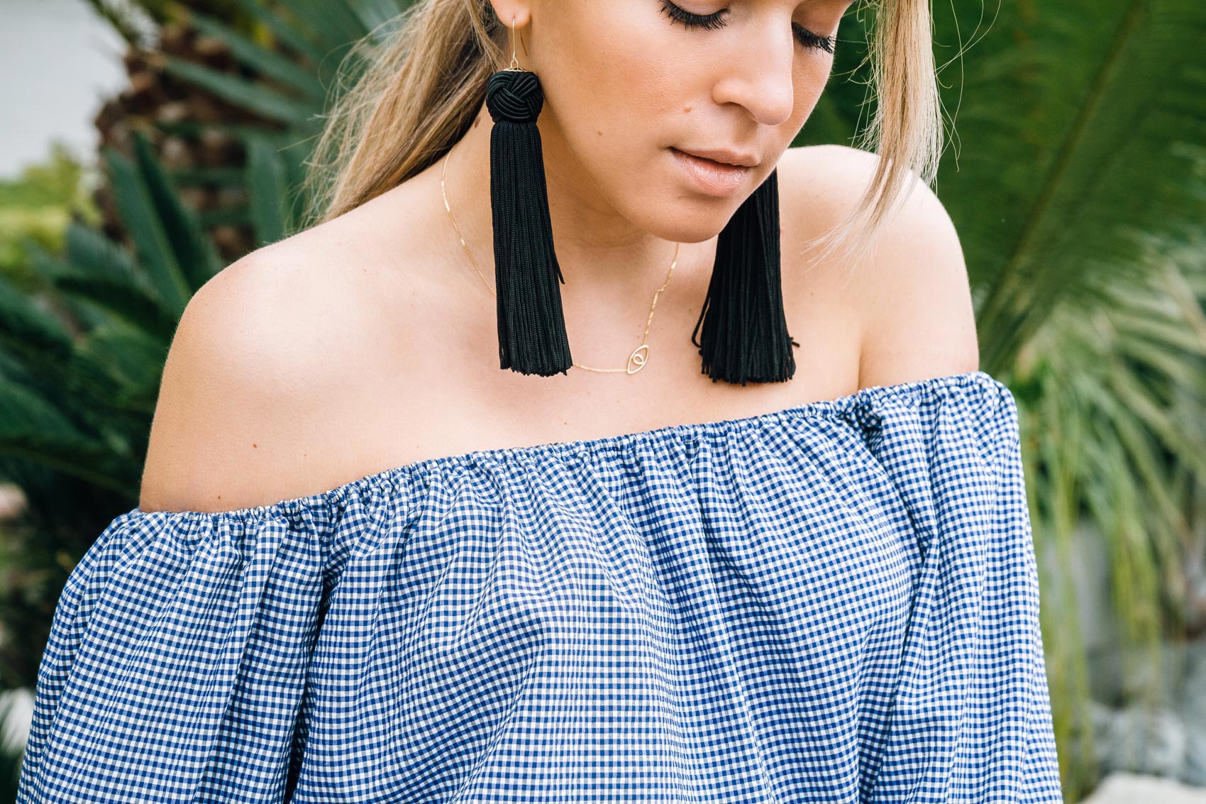 Maristella pairs statement tassel earrings with an off the shoulder top