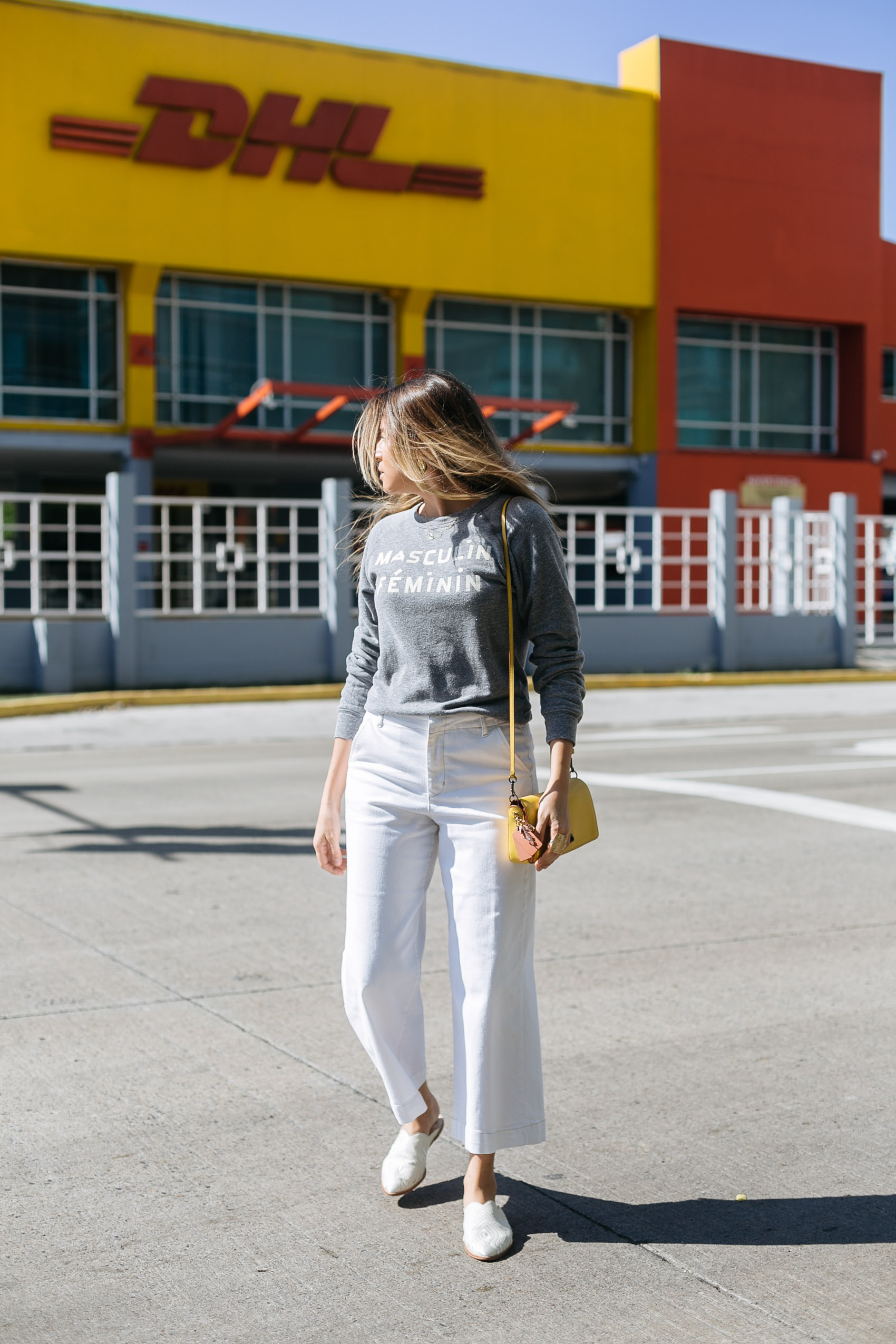 Maristella wearing a Clare V sweatshirt with white denim and mules