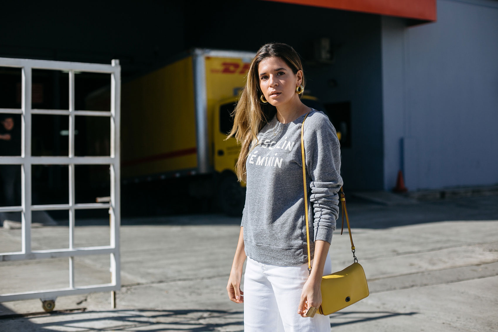 Maristella wearing a Clare V sweatshirt with Zara white denim and Coach bag