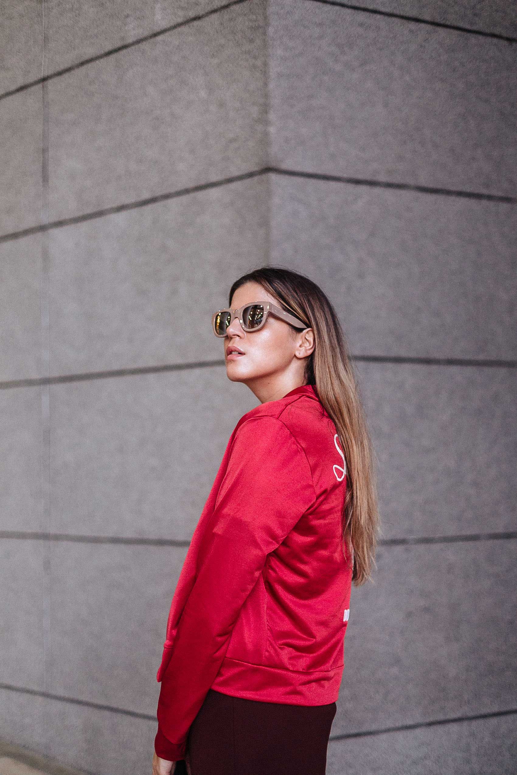 Maristella wearing nude frame mirrored sunglasses from Acne Studios, red satin embroidered jacket from Zara, dark red structured skirt from H&M
