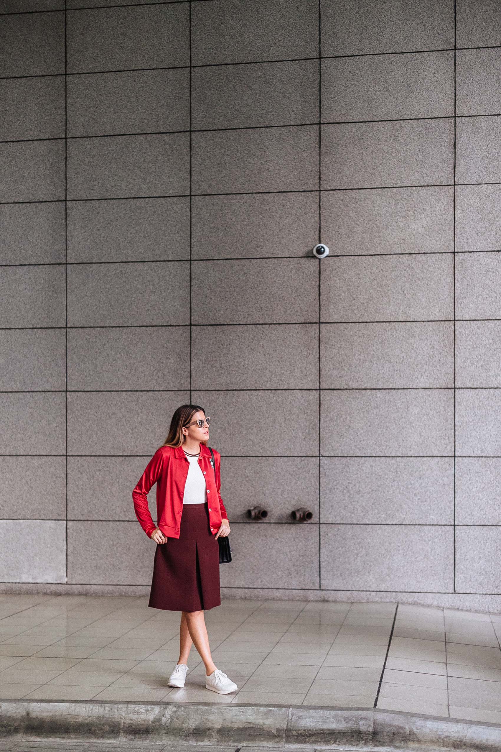 Maristella wears a red bomber jacker, ribbed ringer top from H&M, structured dark red A line skirt from H&M, sneakers from Zara and bag from Yves Saint Laurent
