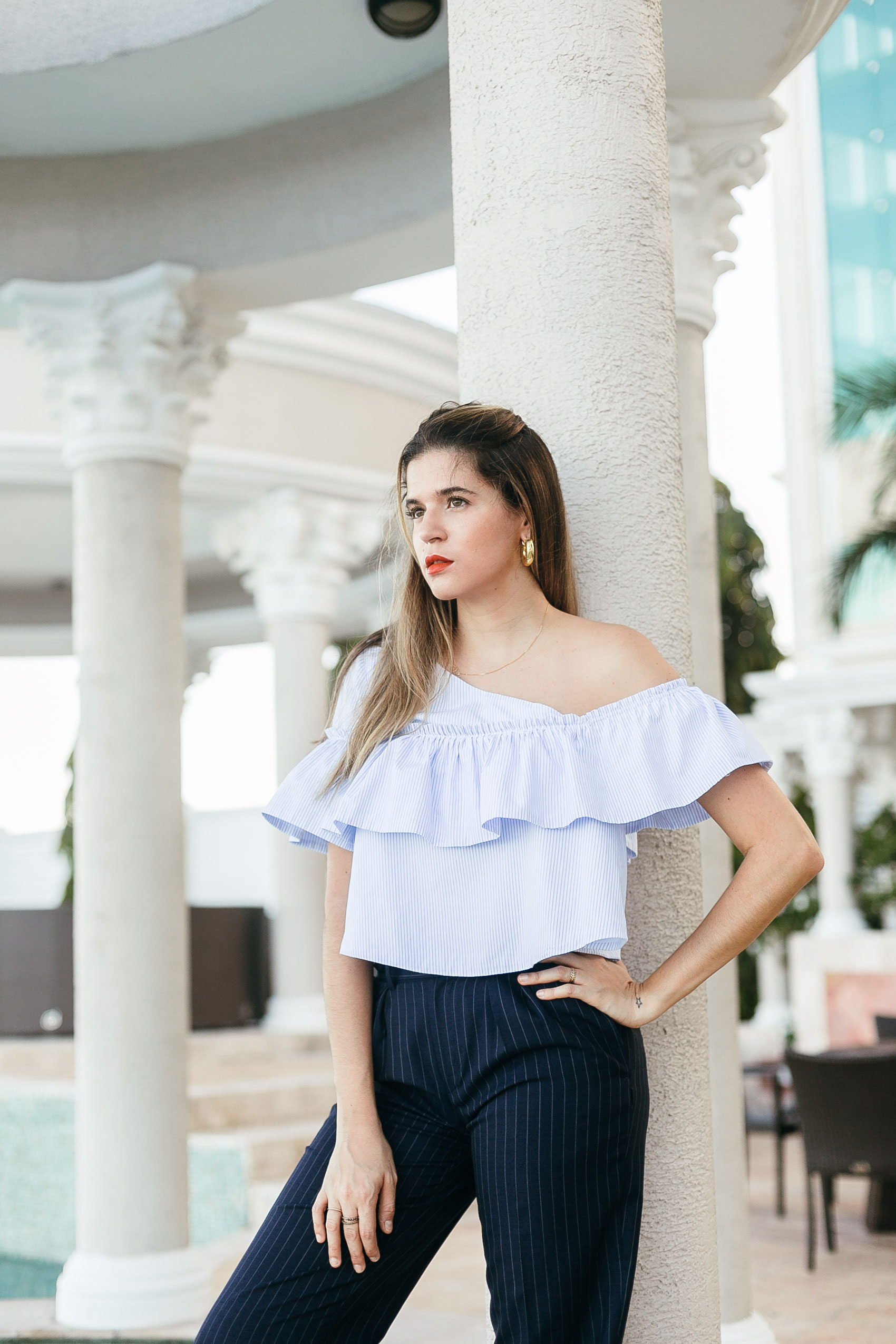Maristella wearing a striped ruffled one shoulder blouse from Zara, navy blue pinstripe trousers from Polo Ralph Lauren, red lipstick from Nars and vintage thick gold hoop earrings