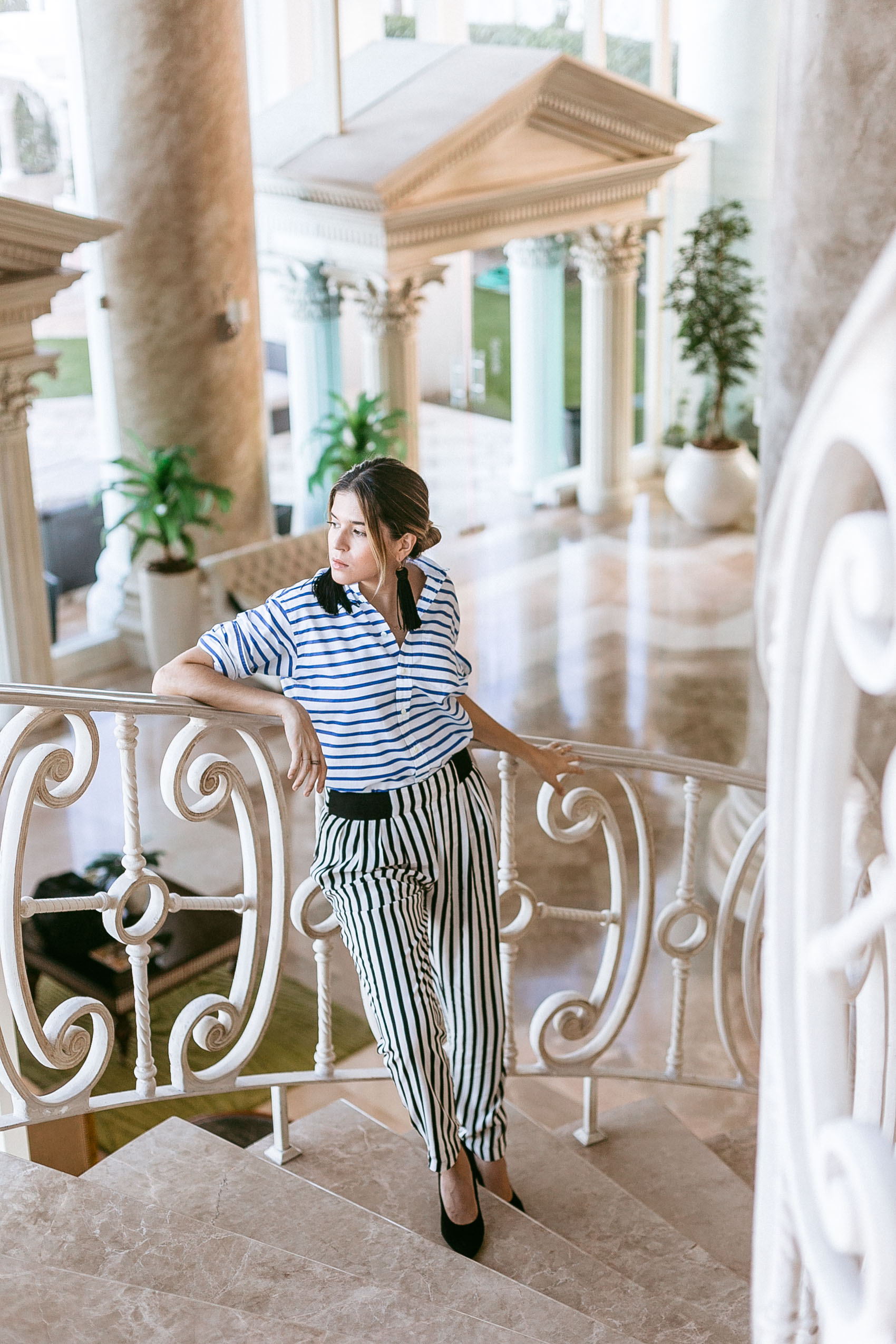 Maristella mixing different color and direction stripes with a Polo Ralph Lauren striped button blouse, Zara stripe trousers, black pumps and statement earrings