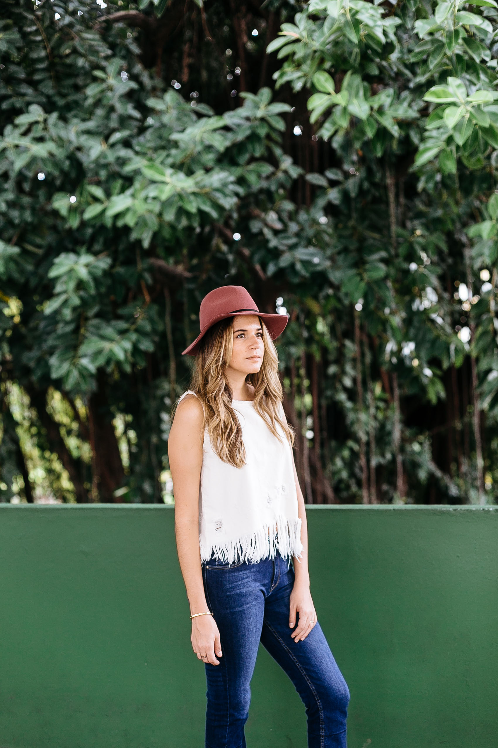 Maristella wears a fedora hat, boxy top and jeans for summer