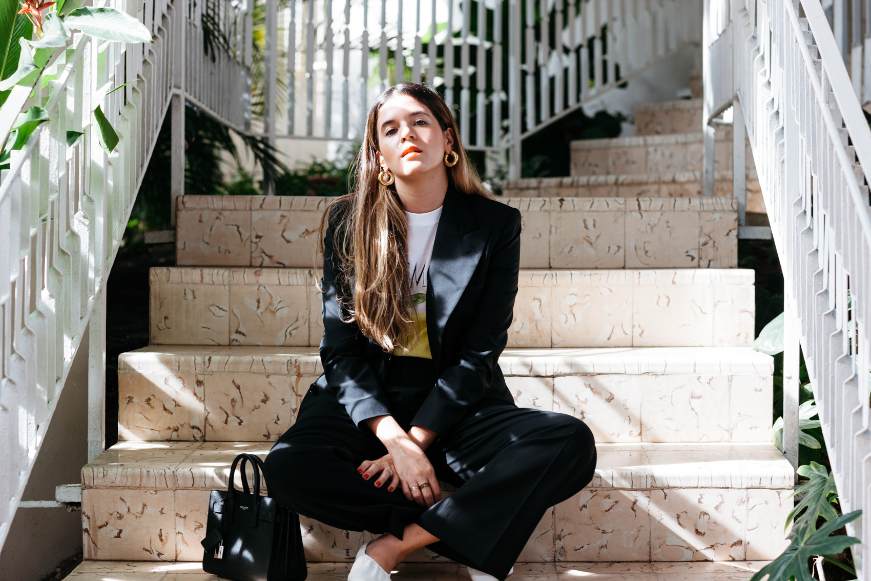 Maristella wears a chic black power suit with flats and a t-shirt