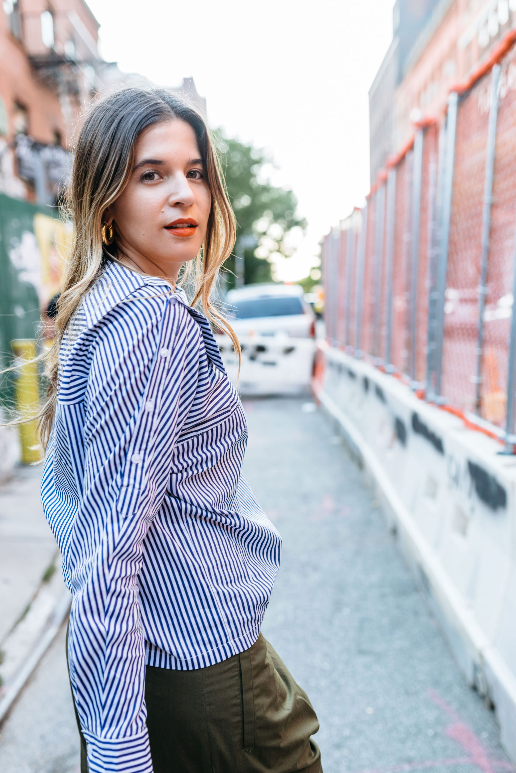 Maristella wears a deconstructed shirt with buttons down the sleeves at New York Fashion Week