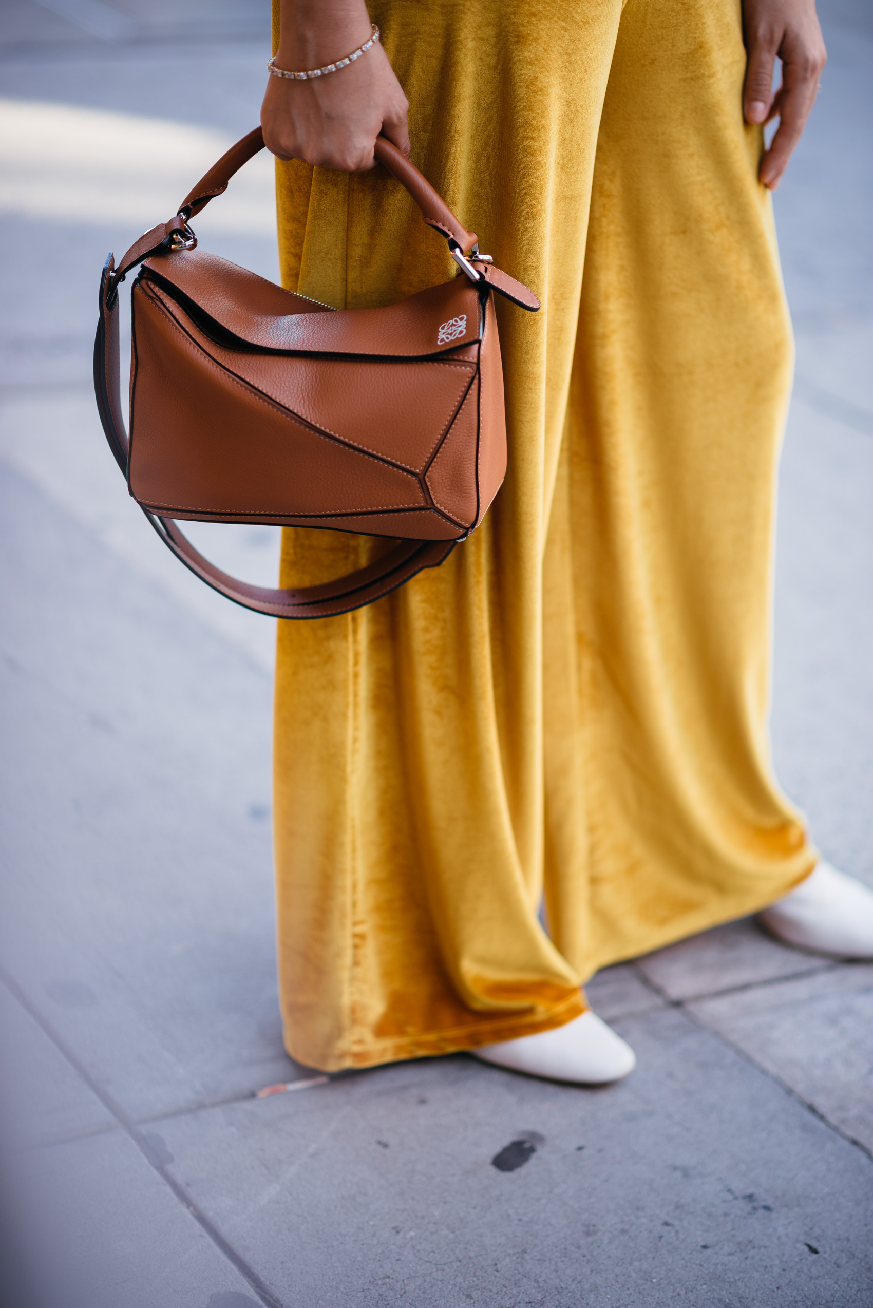 Maristella wearing mustard yellow velvet and a Loewe small puzzle bag in tan leather