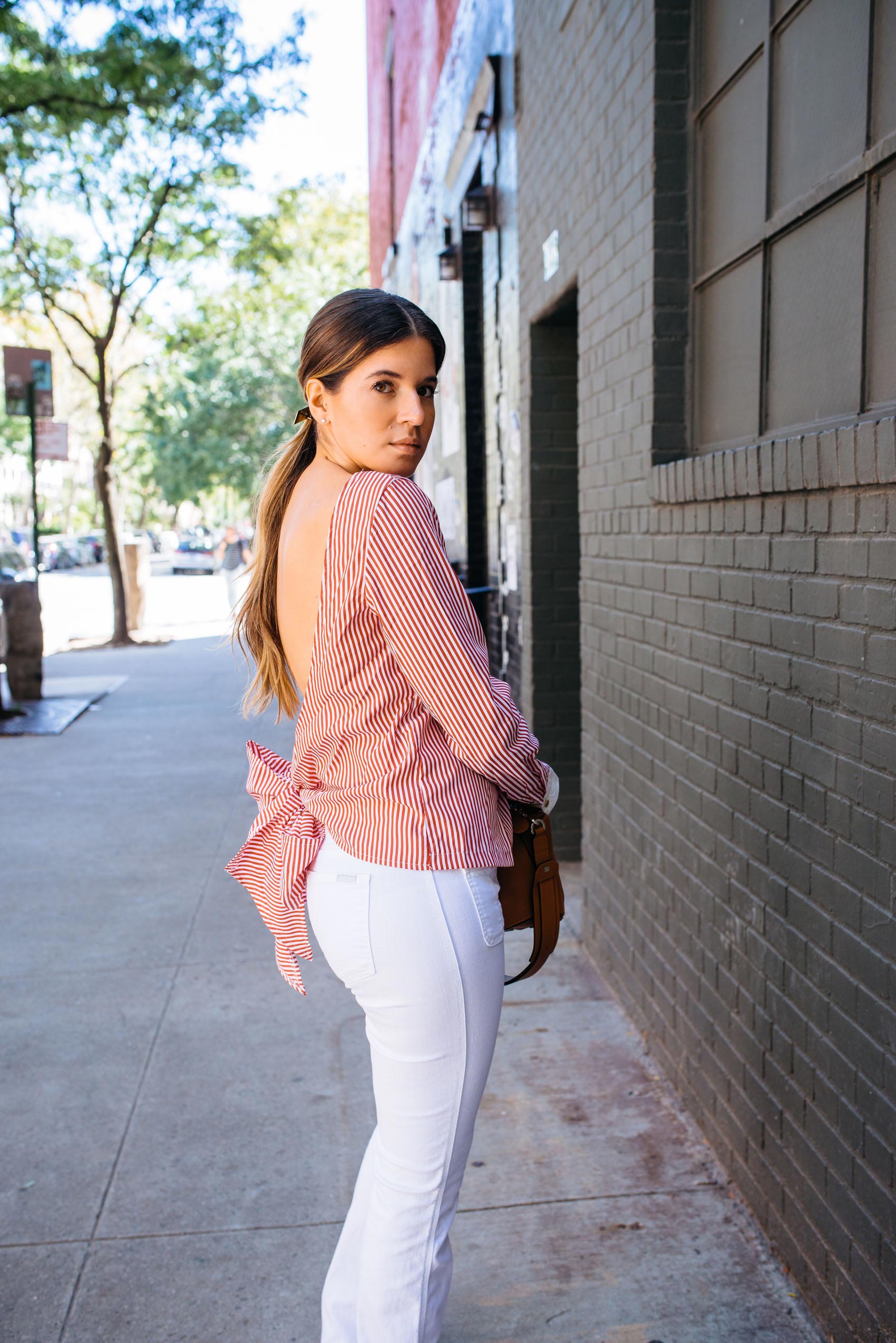 Maristella wears a striped blouse with flared jeans in New York City