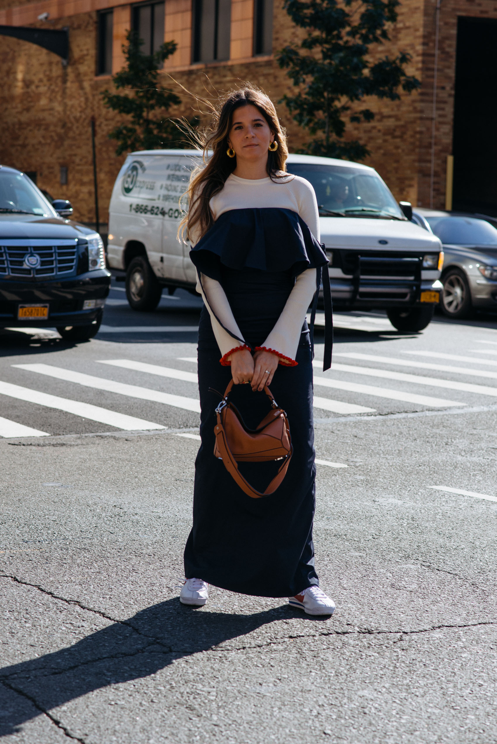 Maristella layering a ribbed knit sweater from Zara under a Fame & Partners blue strapless dress with Nike Cortez sneakers, Loewe puzzle bag