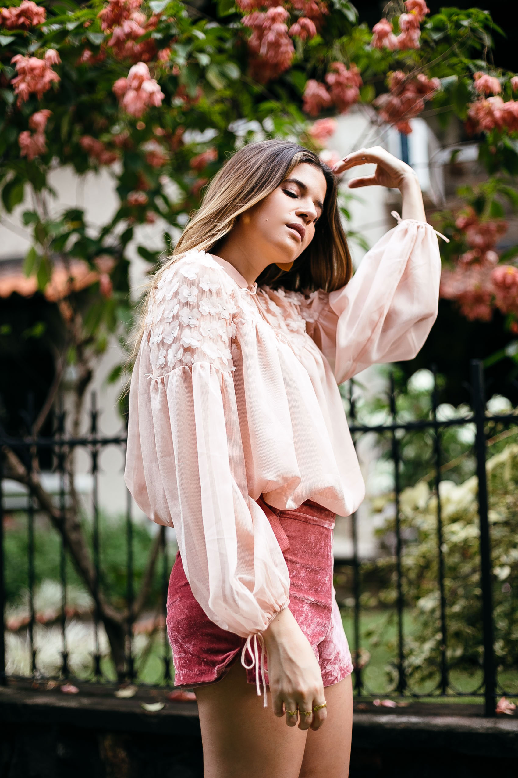 Maristella wears a romantic pink blouse with rose velvet shorts