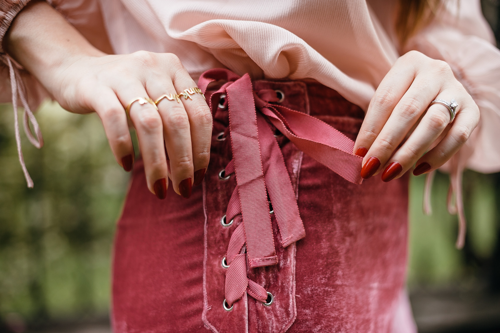 Dainty rinds, velvet side tie shorts in pink rose, red oval manicure nails and a blush blouse