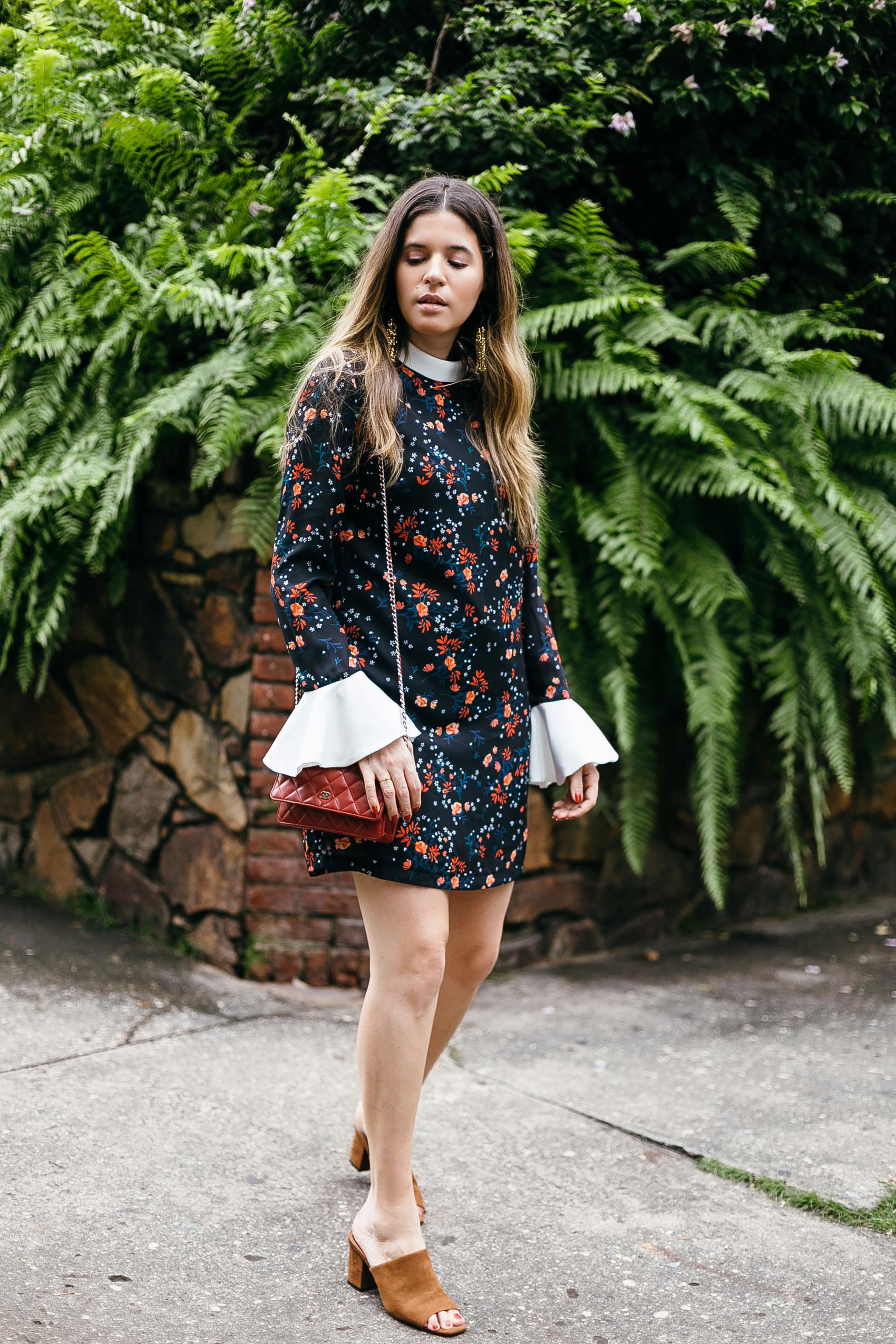 Maristella wearing a tunic floral dress from Endless Rose with contrast white flared sleeves, Chanel red mini bag, brown suede mules