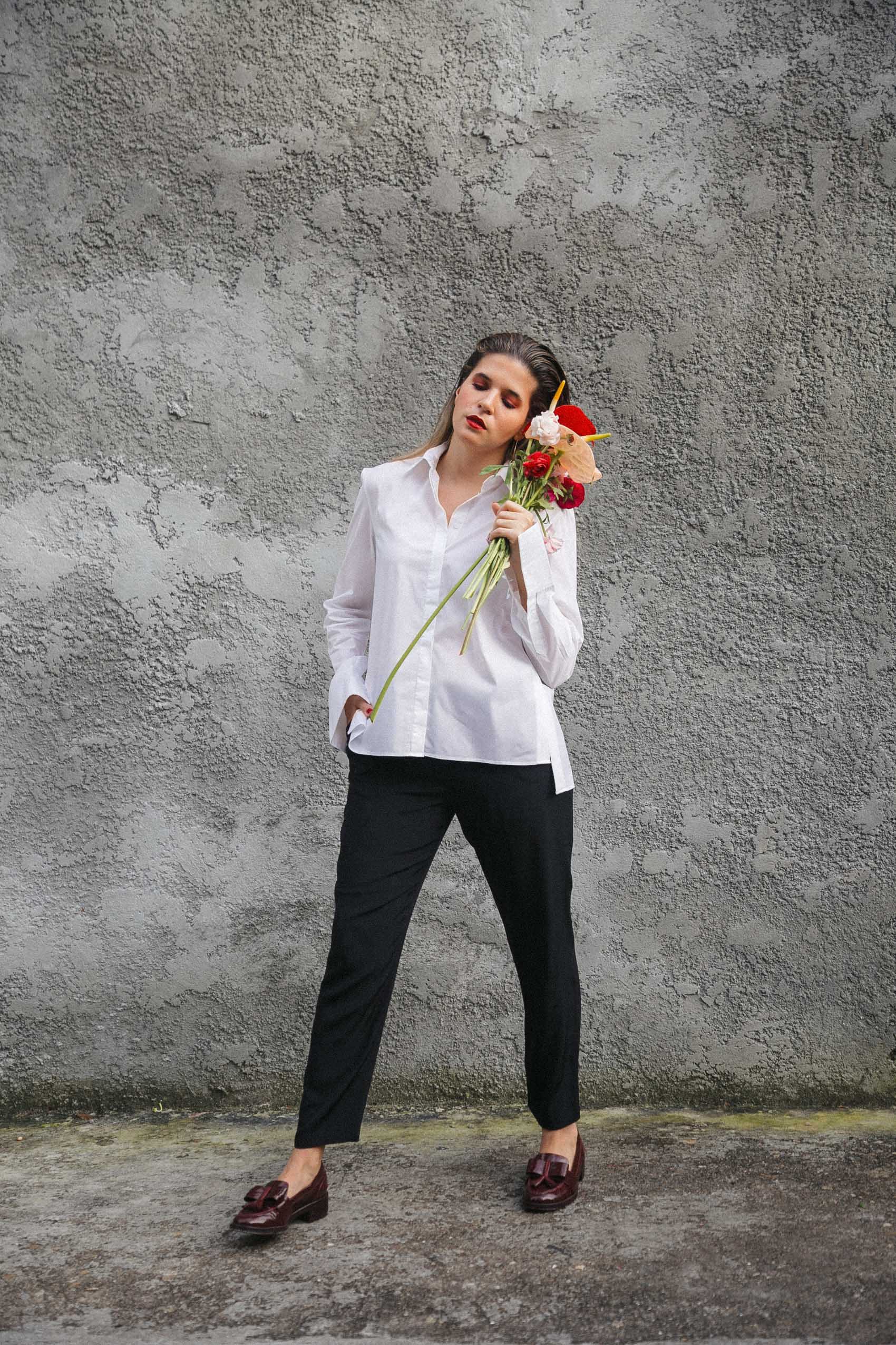 Maristella wearing Tory Burch loafers, black silk trousers and white button down shirt with side buttons