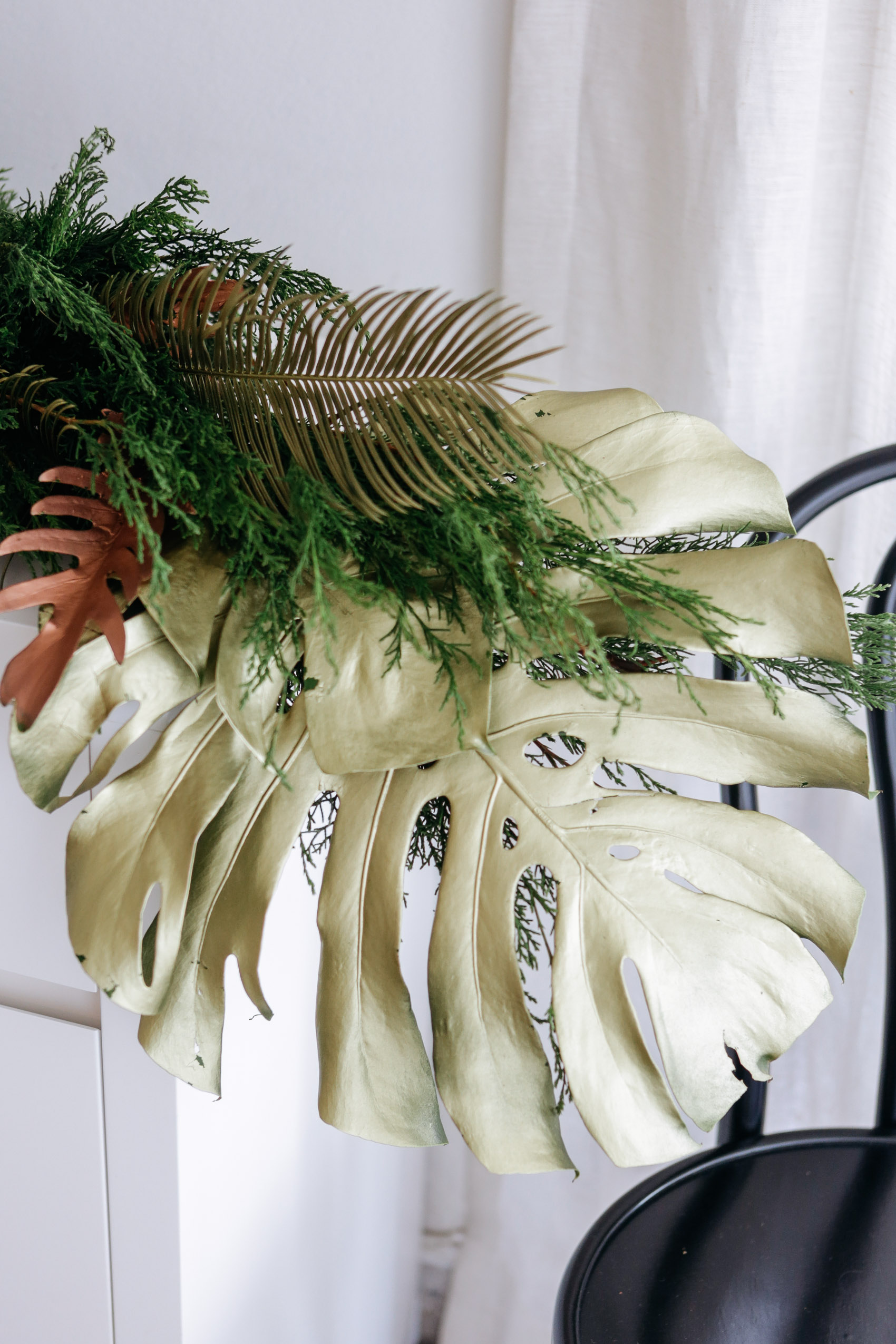 Gold painted monstera leaf with pine garland decoration for Christmas
