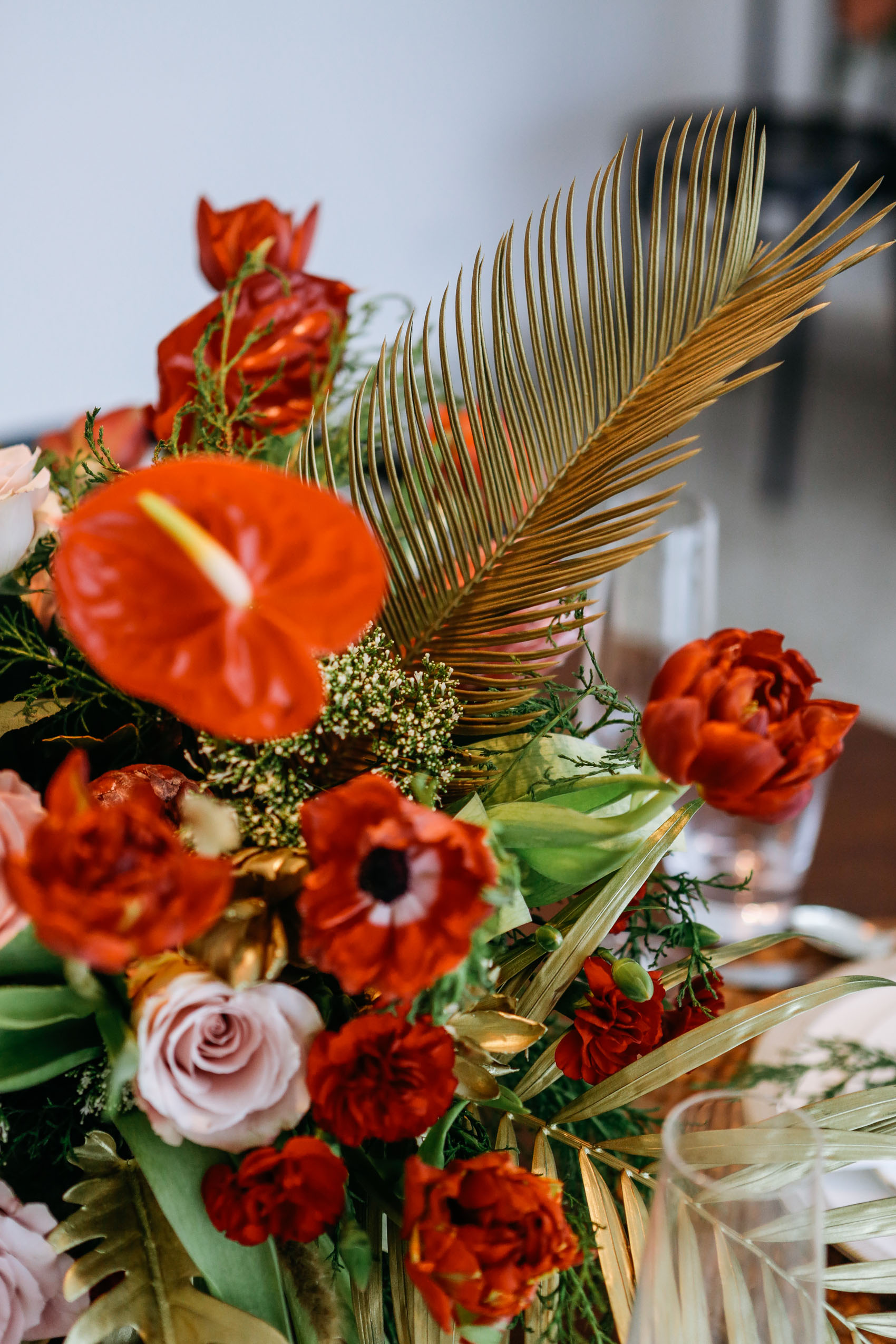 Anthurium, anemone, carnation and gold painted palm leaf flower arrangement by Silvatica Flores