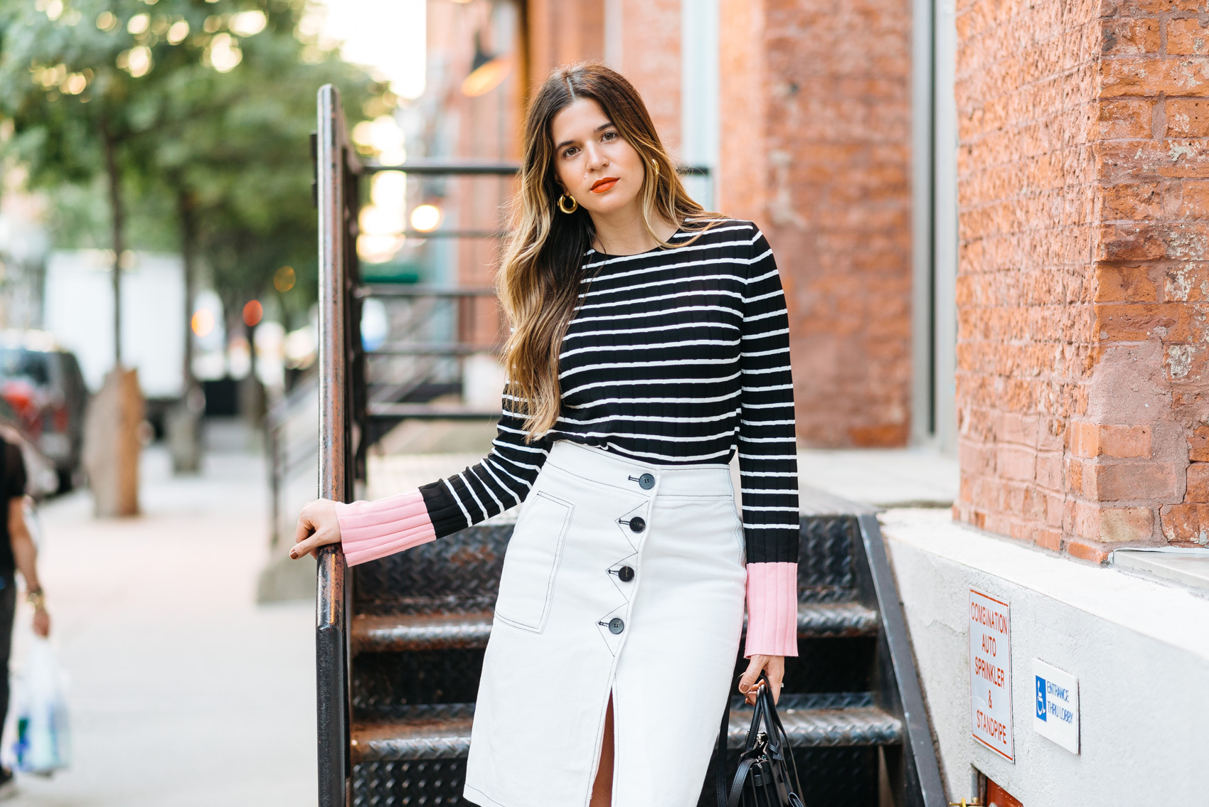 Maristella in a stripe sweater from Zara with pink flared sleeves and skirt from Style Mafia