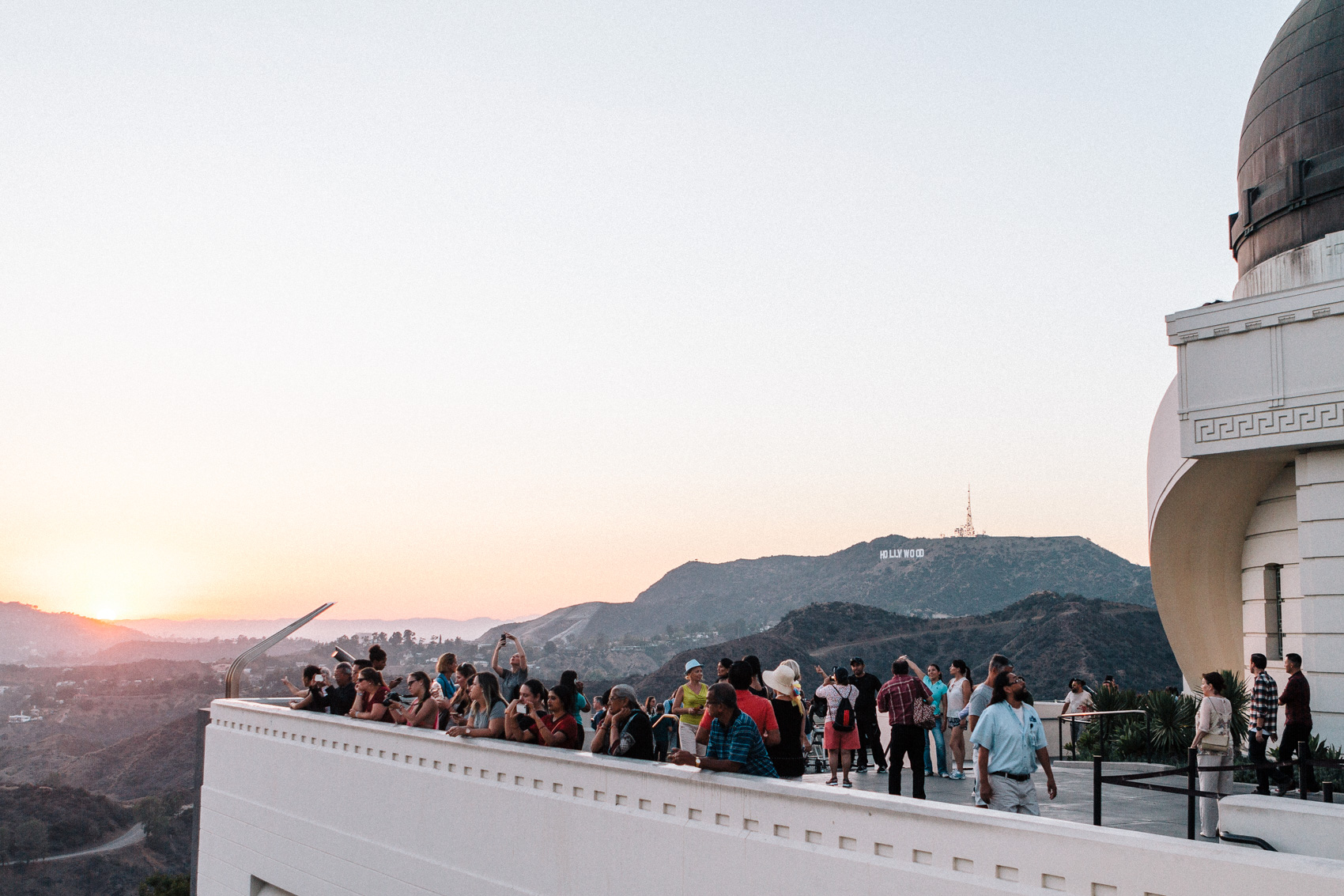 Visitors enjoying the sunset from the Griffith Observatory, against the Hollywood Hills and the Hollywood Sign