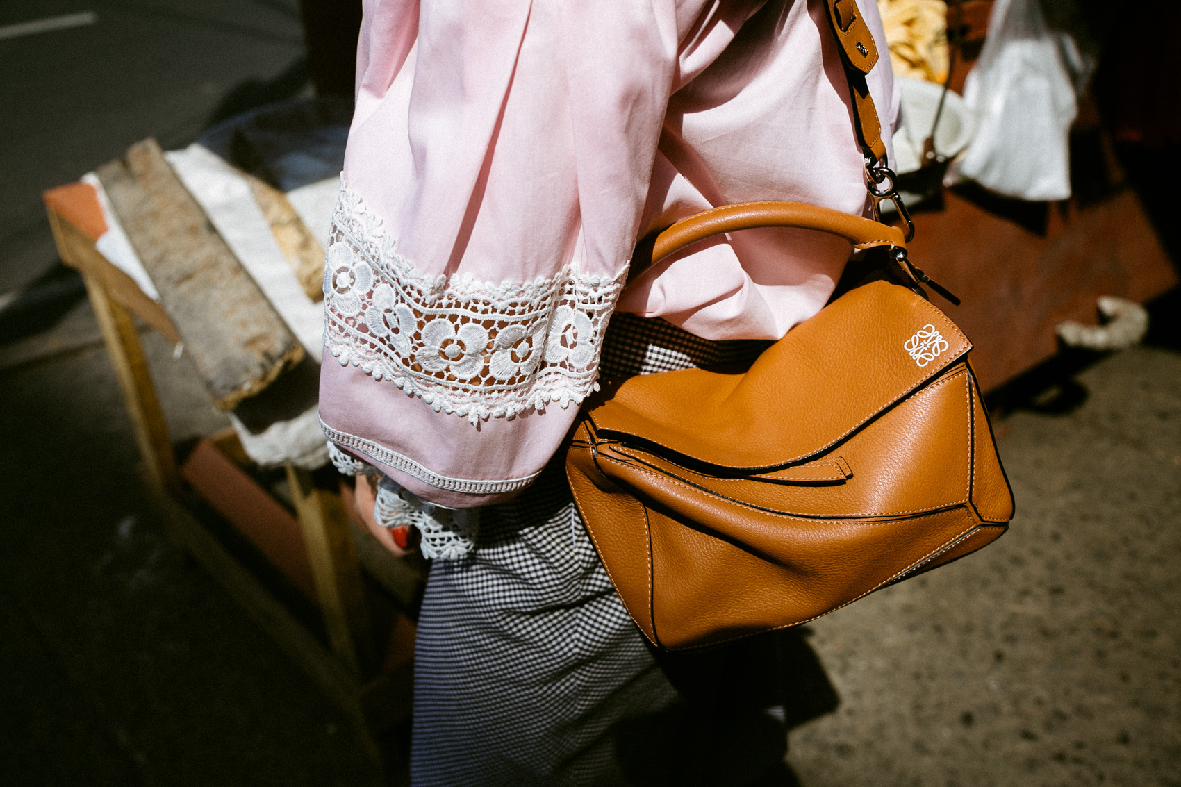 Pink blouse with lace details, Loewe puzzle bag and gingham skirt
