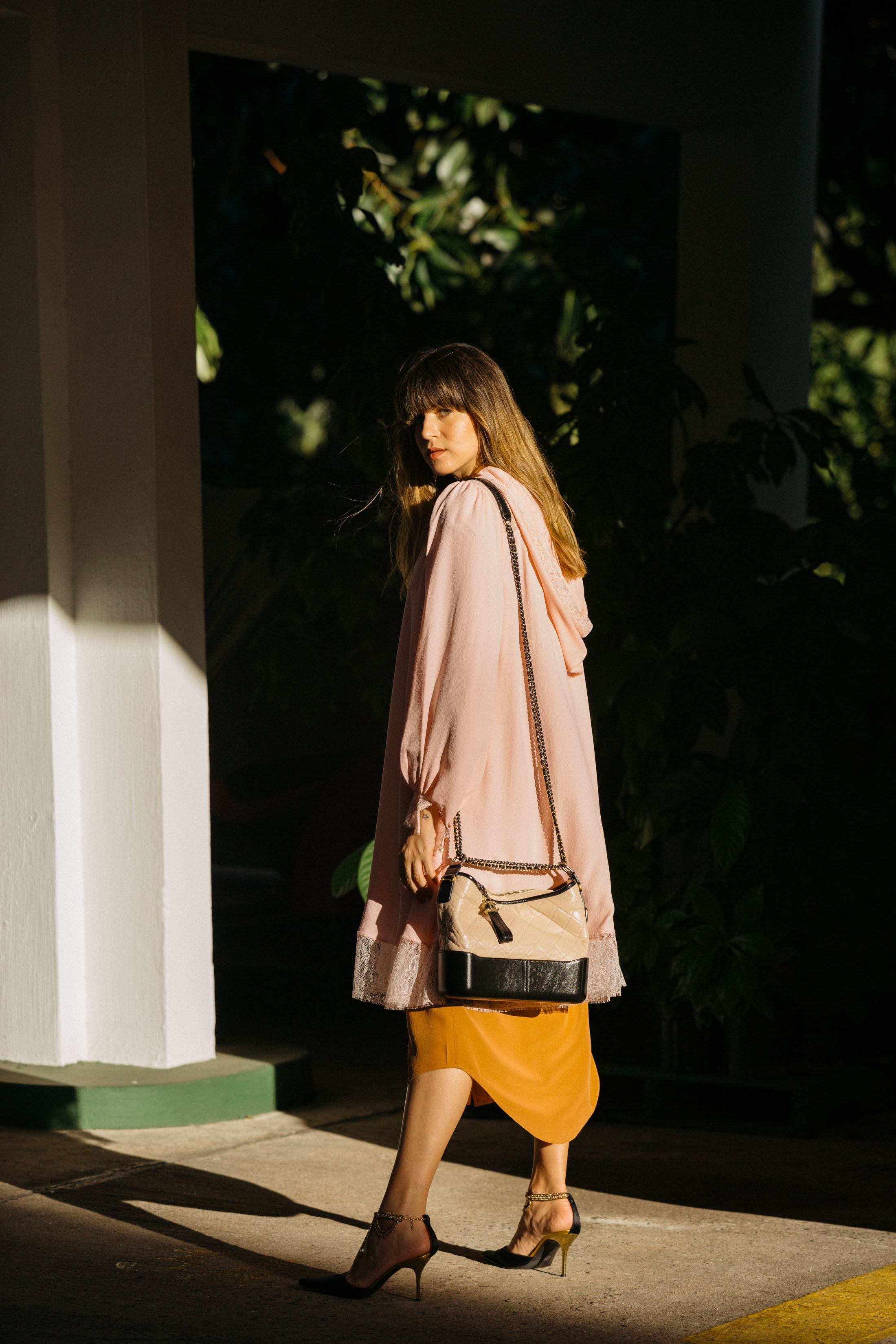 Maristella wears a pink hooded robe and bag from Chanel