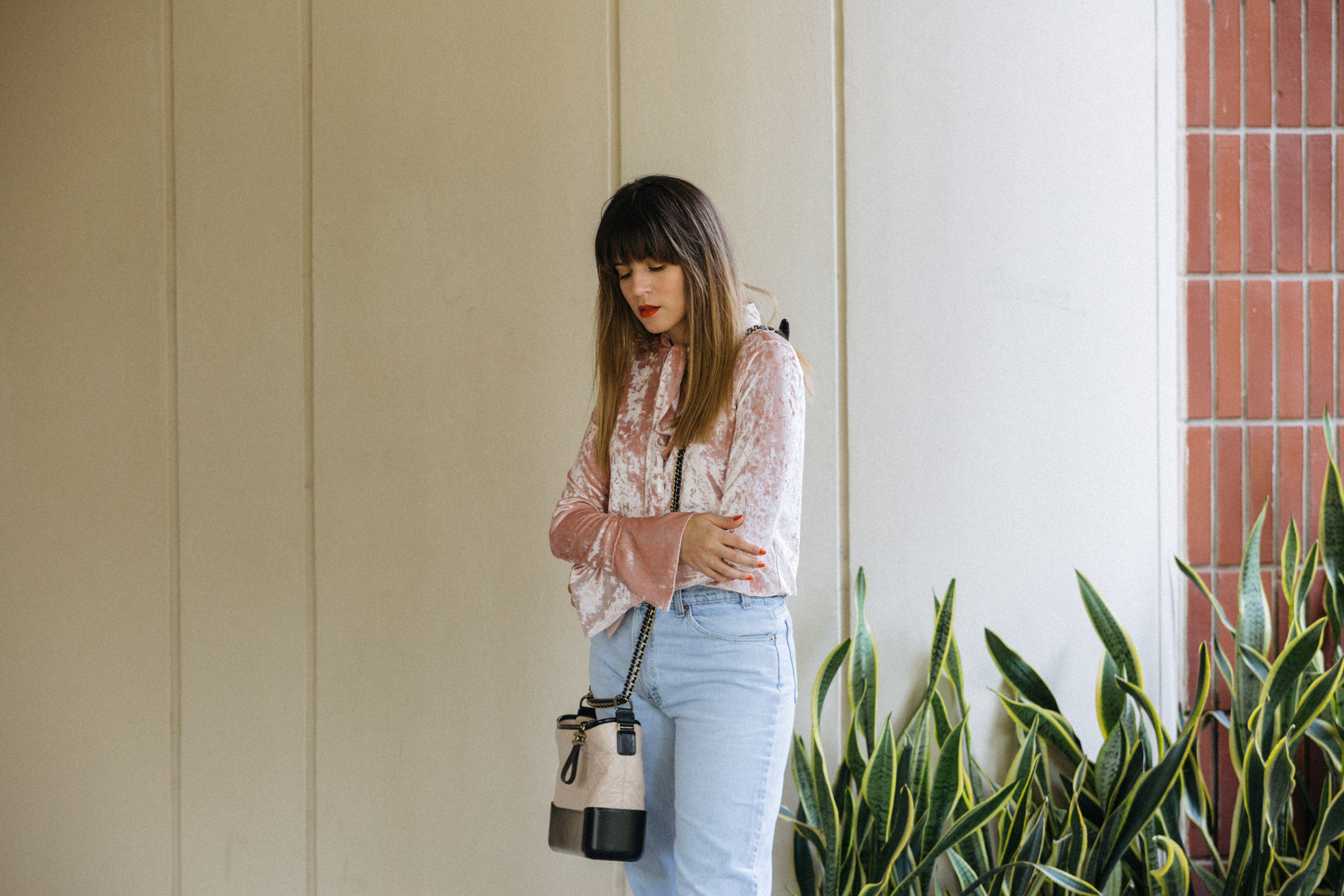 Maristella wears a crushed pink velvet shirt with pussy bow, vintage Levi's jeans and the Chanel Gabrielle bag as a long cross body bag