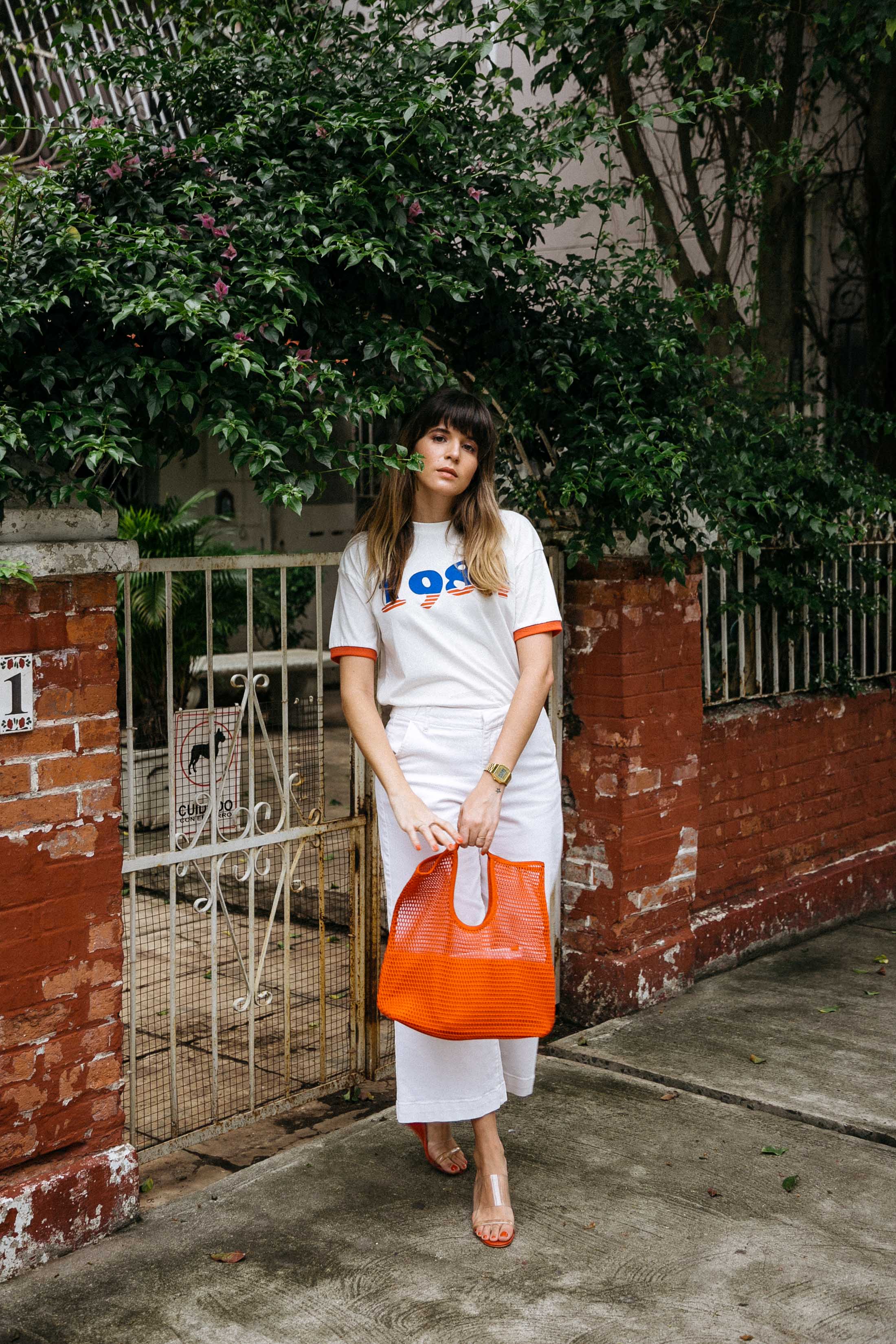 Maristella wears a graphic tee with jeans and wedge sandals