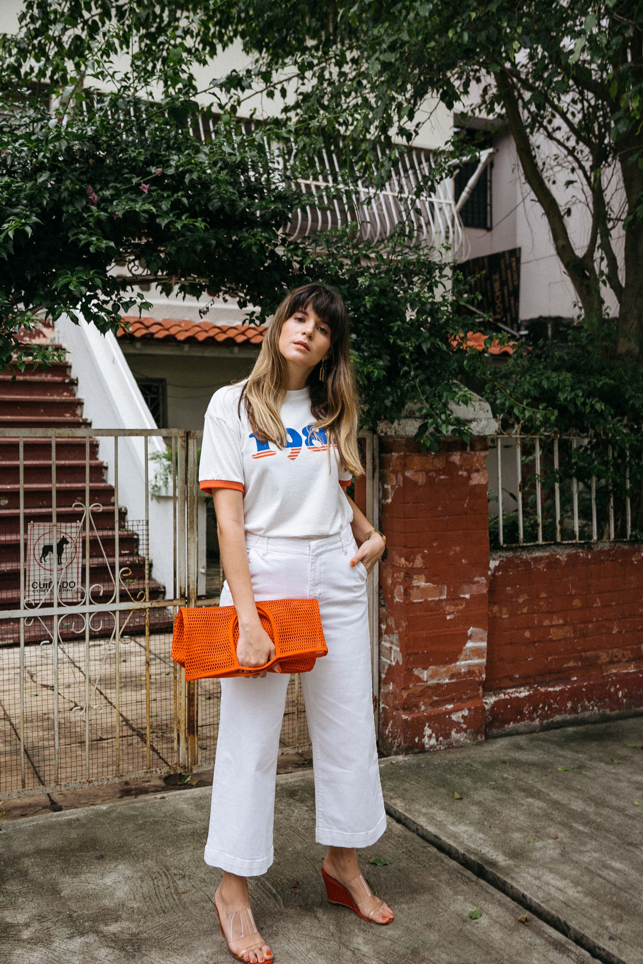 Maristella wears white wide leg jeans with a graphic ringer tee