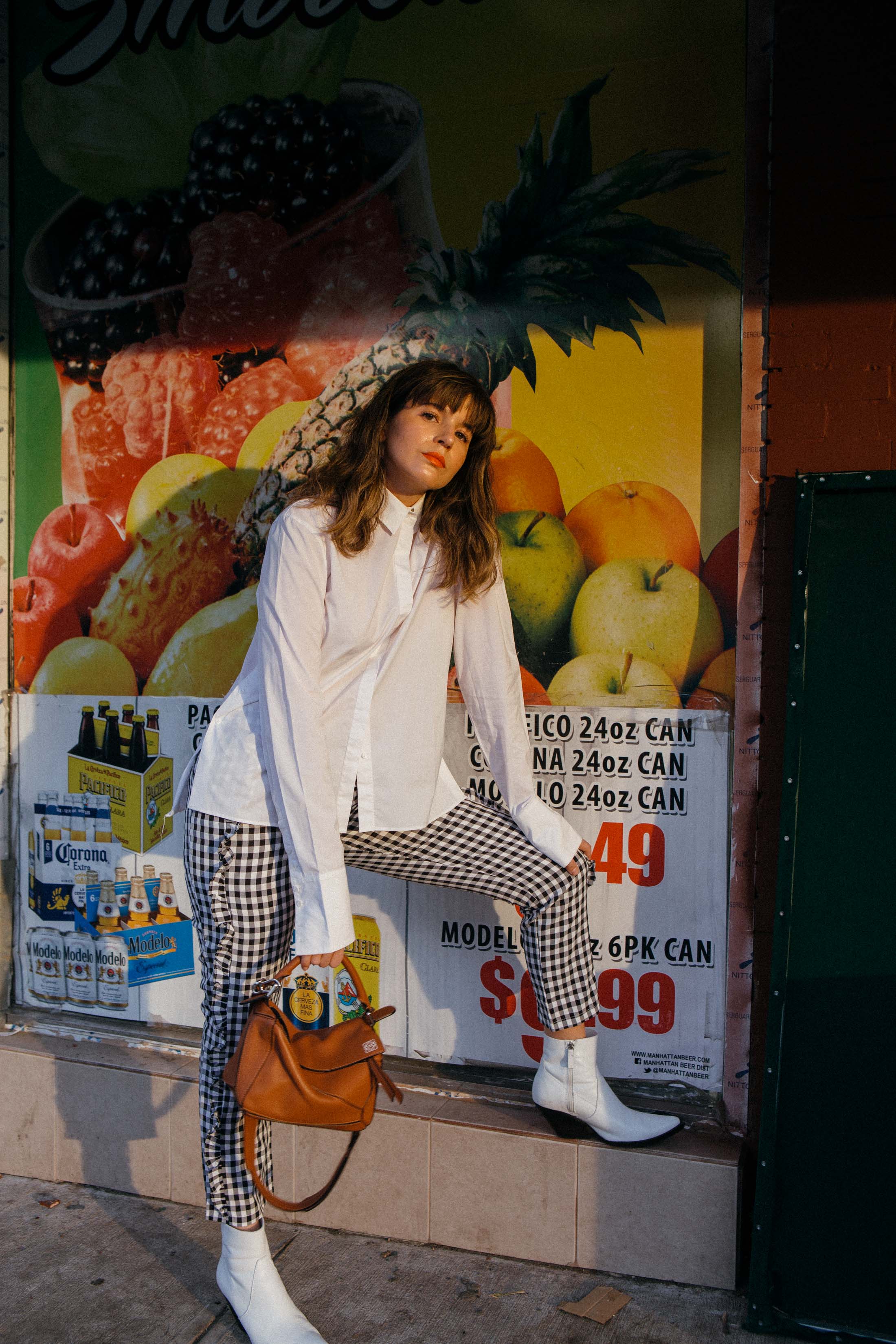 Maristella wears black and white gingham pants with white cowboy boots