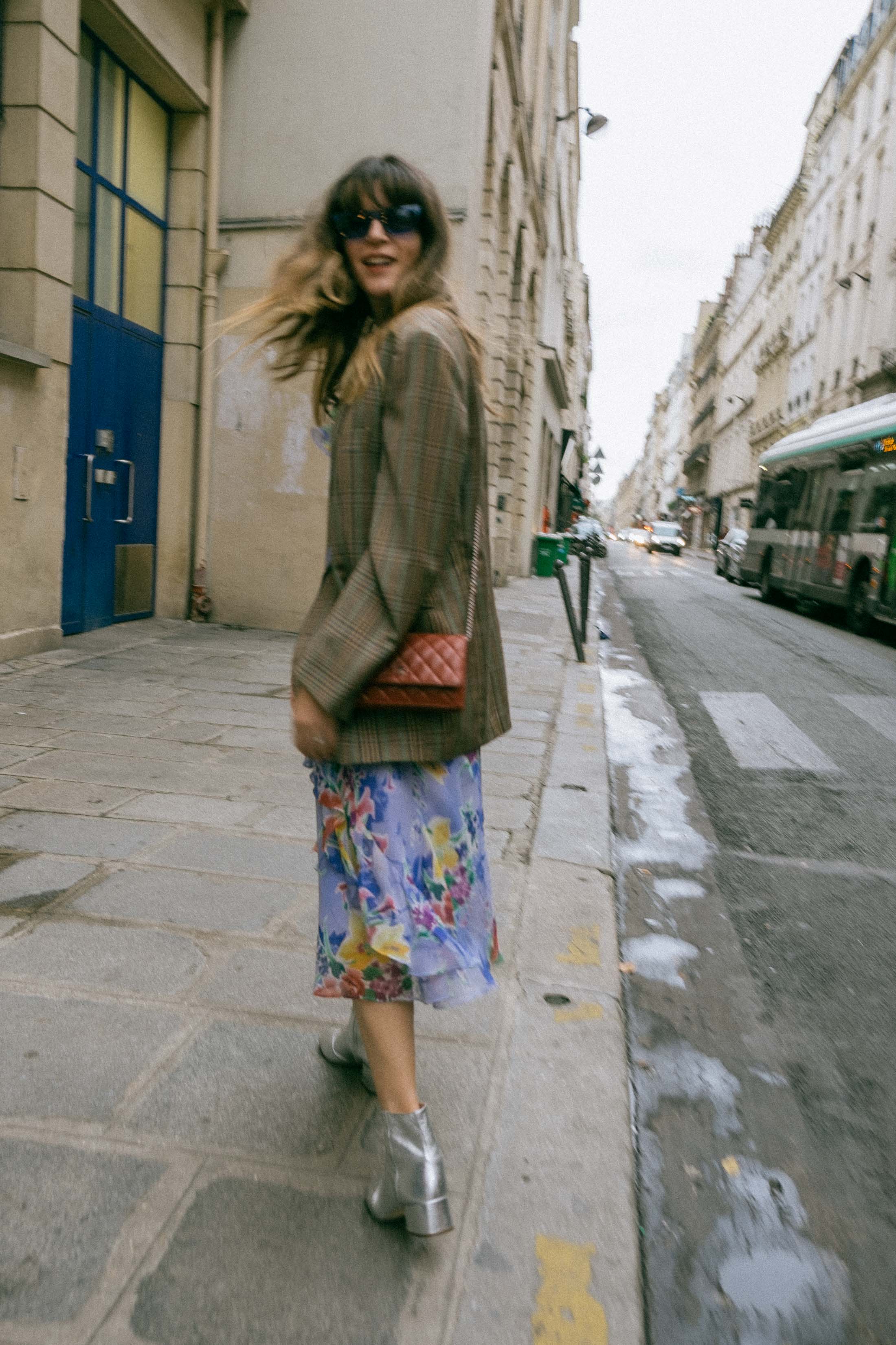 Maristella wears a vintage men's blazer, vintage floral dress, Loeffler Randall silver boots and mini burgundy Chanel crossbody bag in Paris