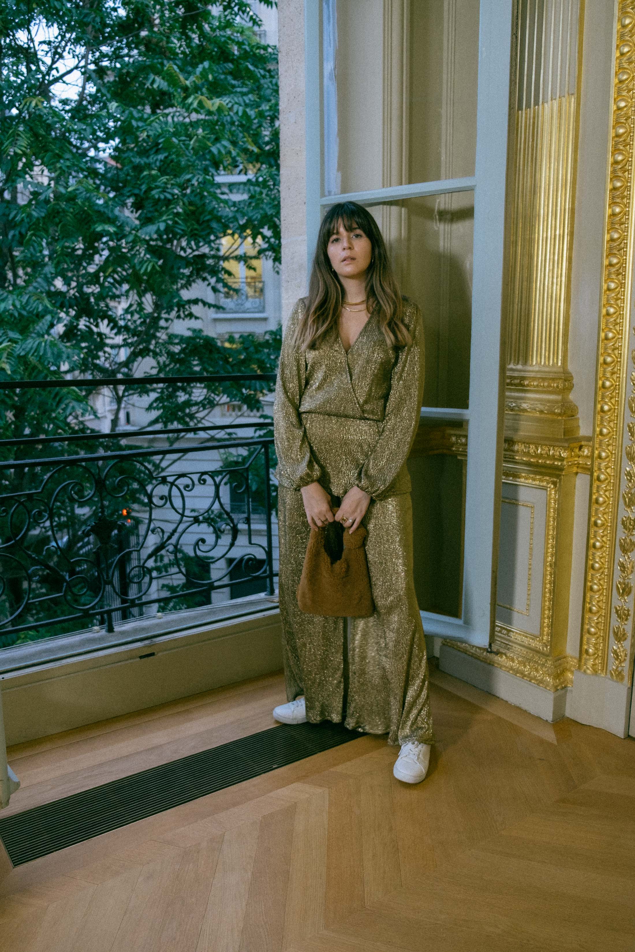 Maristella in a gold coordinated blouse and pants set with white sneakers and a teddy Loeffler Randall bag at the Ellery Presentation in Paris Fashion Week